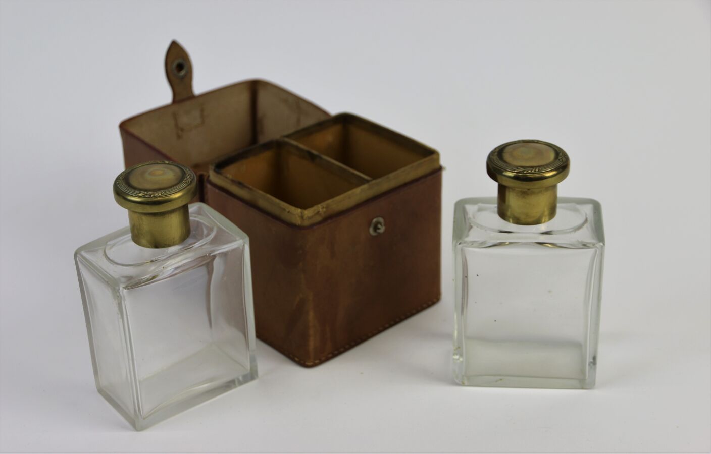 Null 法国作品（20世纪20年代）

平滑的绗缝皮革旅行箱内装有两个无色的水晶旅行瓶，带有冲压的铜质支架和盖子。

瓶子的高度：11.5厘米