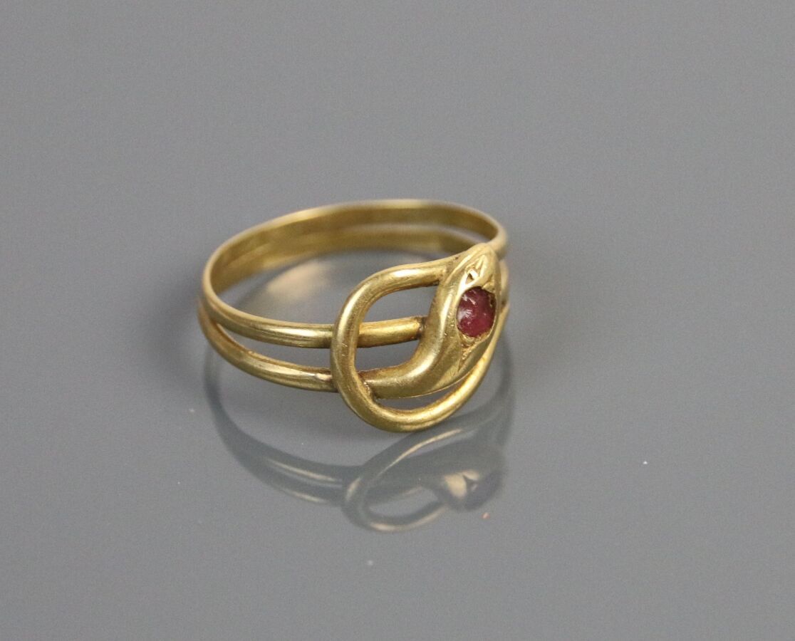 Null 750°/°的黄金戒指，部分镂空，以盘蛇为特色，镶有红色宝石。

TDD : 56 - 毛重 : 2,8 g