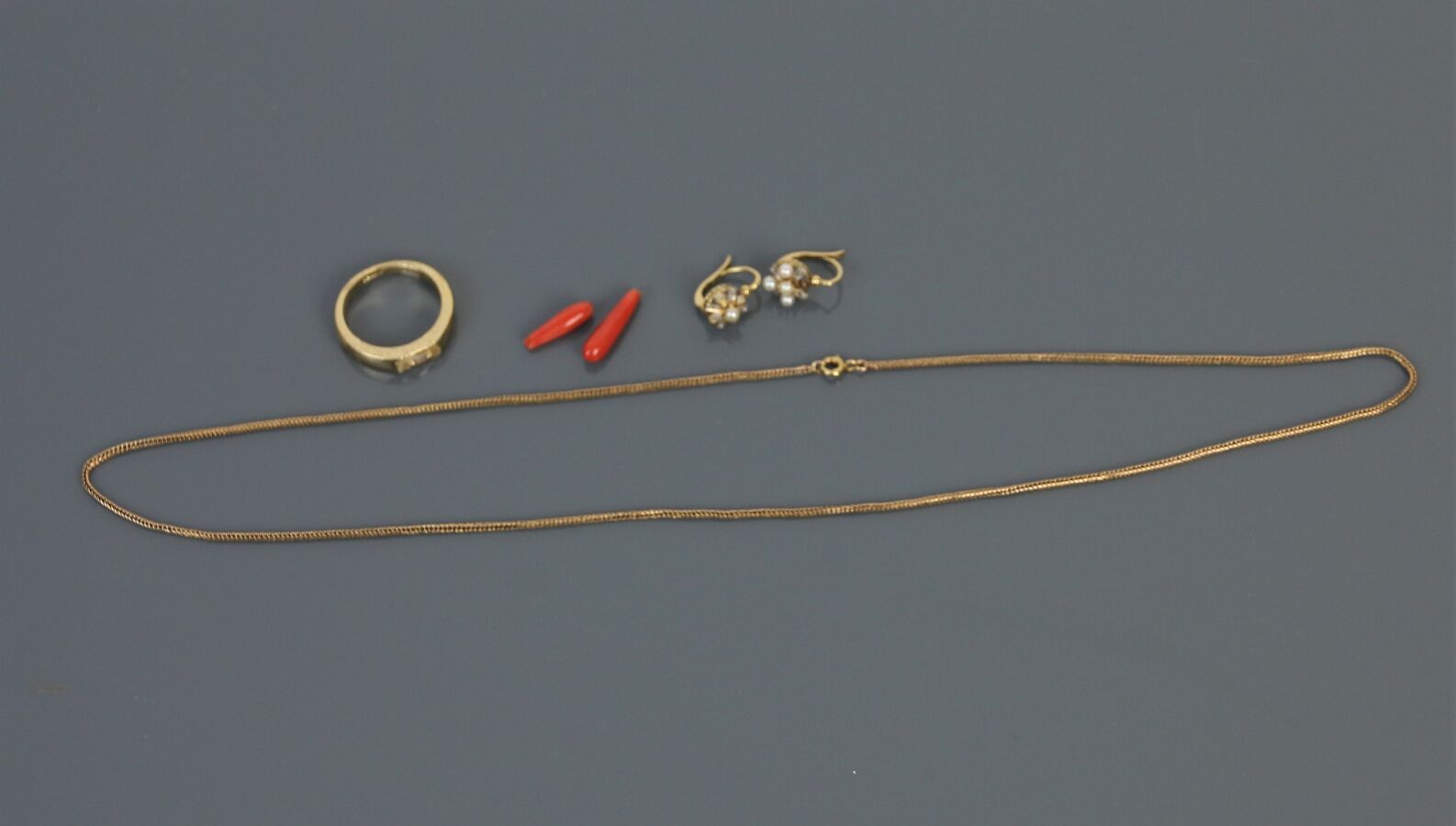 Null 750°/°的黄金链条，人字形链节。

一对750°/°的黄金和白金Dormeuses，装饰有珍珠（缺失）。

总毛重：3.7克

两个红珊瑚吊坠和一&hellip;