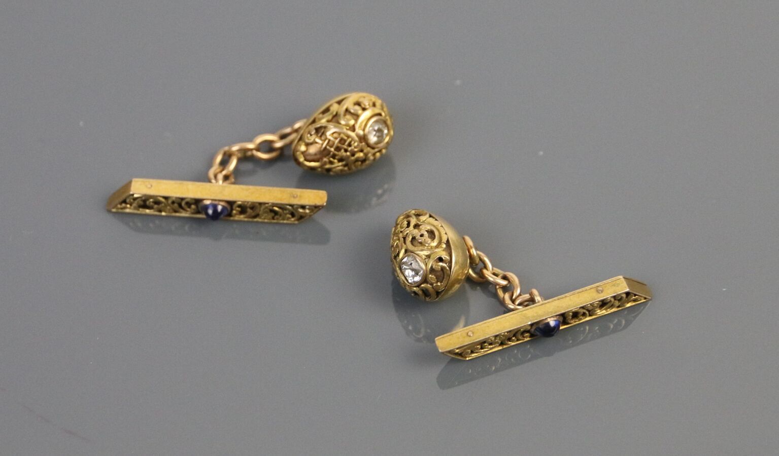 Null 一对585°/°黄金袖扣，有凹凸不平的装饰，每个袖扣都镶嵌有凸圆形蓝宝石和一朵钻石玫瑰。

毛重：8.7克