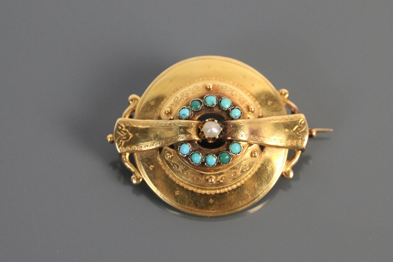 Null 750°/°黄金圆形胸针，精雕细琢的装饰，镶有绿松石，中间是半颗珍珠。

19世纪中期的法国作品。

尺寸 : 4,3 cm - 毛重 : 6,4 g