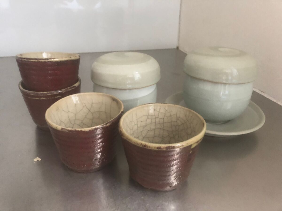Null 一套由四个葡萄酒色的小陶瓷碗组成，内部有裂纹的青瓷。

附有两个小碗，两个杯子和一个青瓷碟子。