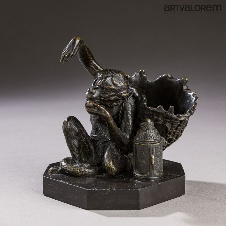 Null Un cendrier pyrogène en bronze patiné figurant un singe mangeant un fruit e&hellip;