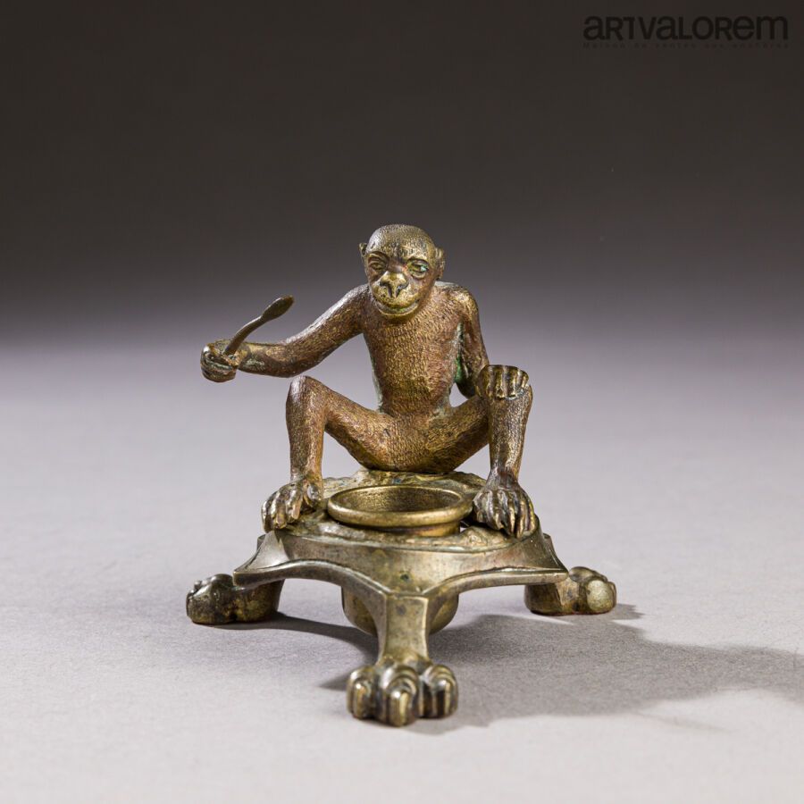 Null 甲骨文三脚架墨水瓶，上面有一只拿着勺子的坐着的猴子，六角形的底座包括一个可移动的杯子，站在三个爪子上。
19世纪晚期。
高度：9厘米 - 长度：10厘&hellip;