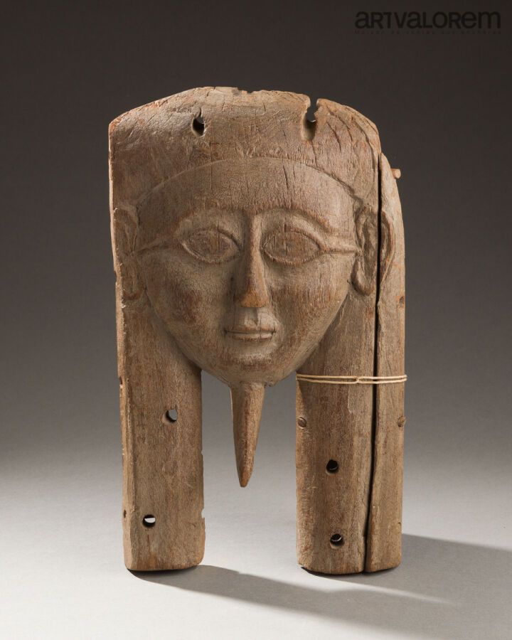 Null 石棺盖上的拟人面具。它梳着三叉式发型，留着假胡须。模糊的眼睛是浮雕。用木钉组装。 
木质。右侧边框缺失。 
埃及。 
H.35.5 厘米 - 21.5&hellip;