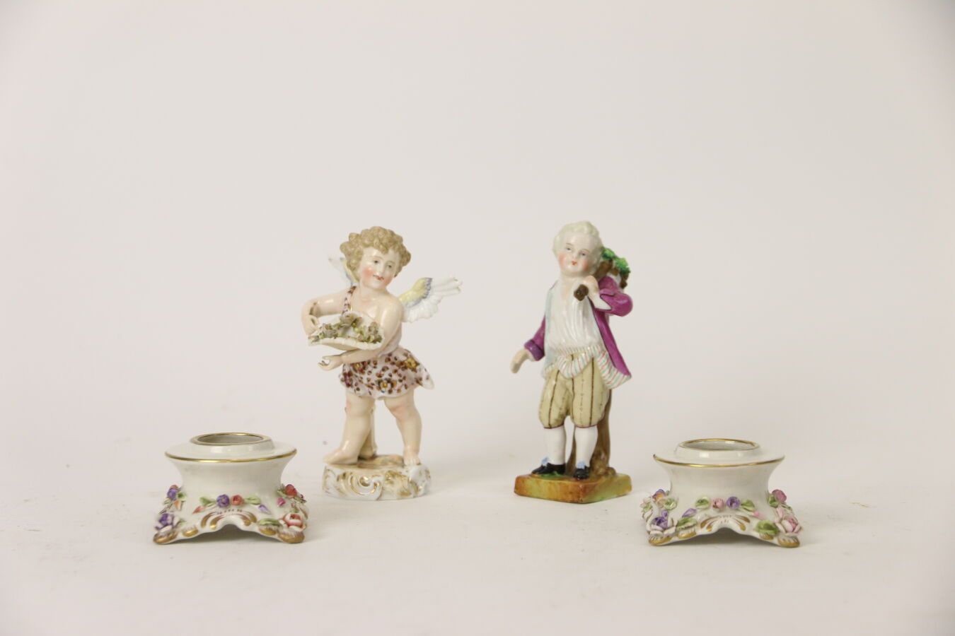 Null Deux statuettes en porcelaine polychrome l'une d'un ange portant une corbei&hellip;