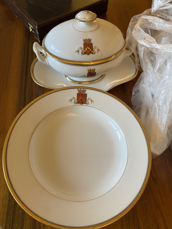 Null Porcelain service with gilded border and coat of arms decoration.