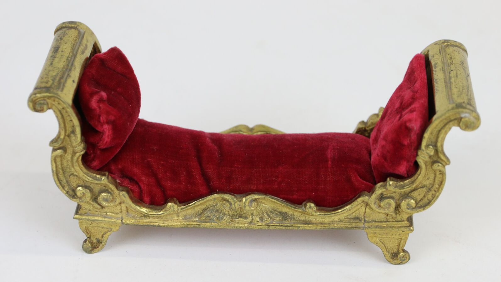 Null 迷你型金银器凹室床，四只弧形床脚上有罗凯尔装饰。
红色天鹅绒软垫。19 世纪作品
尺寸：6.5 x 14.5 x 5 厘米