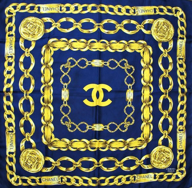 Null CHANEL 
Foulard en soie imprimée de chaines siglées dorées sur fond bleu ma&hellip;
