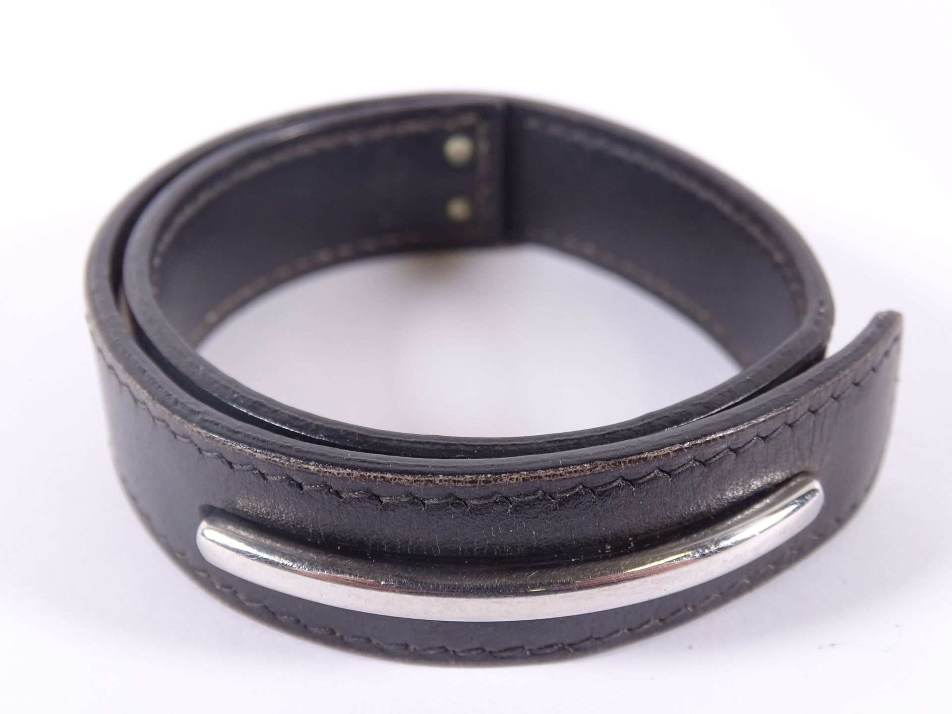 HERMES Armband aus schwarzem Leder mit doppelter Windung und Spangendekor.

Durc&hellip;
