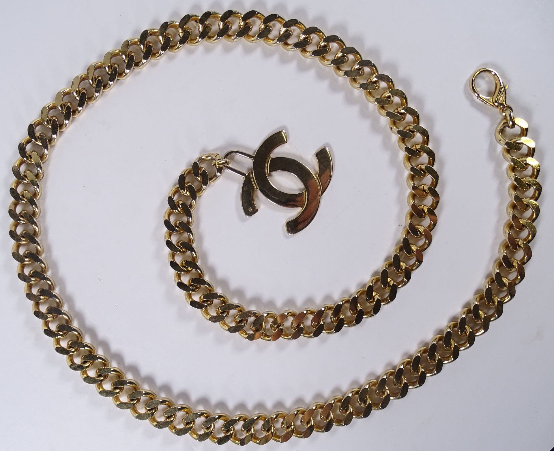 CHANEL 鎏金铜带，forçat链接。

扣子上装饰有字母图案。

总长度：105厘米。

(可调整)。