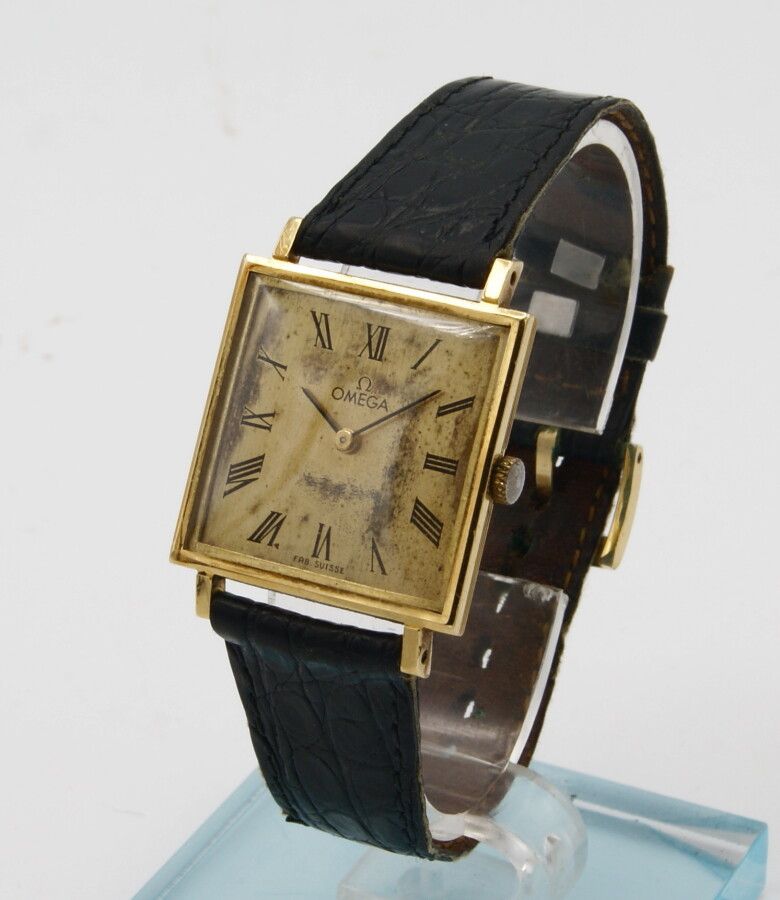 Null 欧米茄18K黄金平面腕表。约1960年。机芯口径620，手动上链。金色表盘。签有欧米茄的字样。罗马数字。(非常氧化)黑色指挥棒指针。方形表壳，背夹式。&hellip;