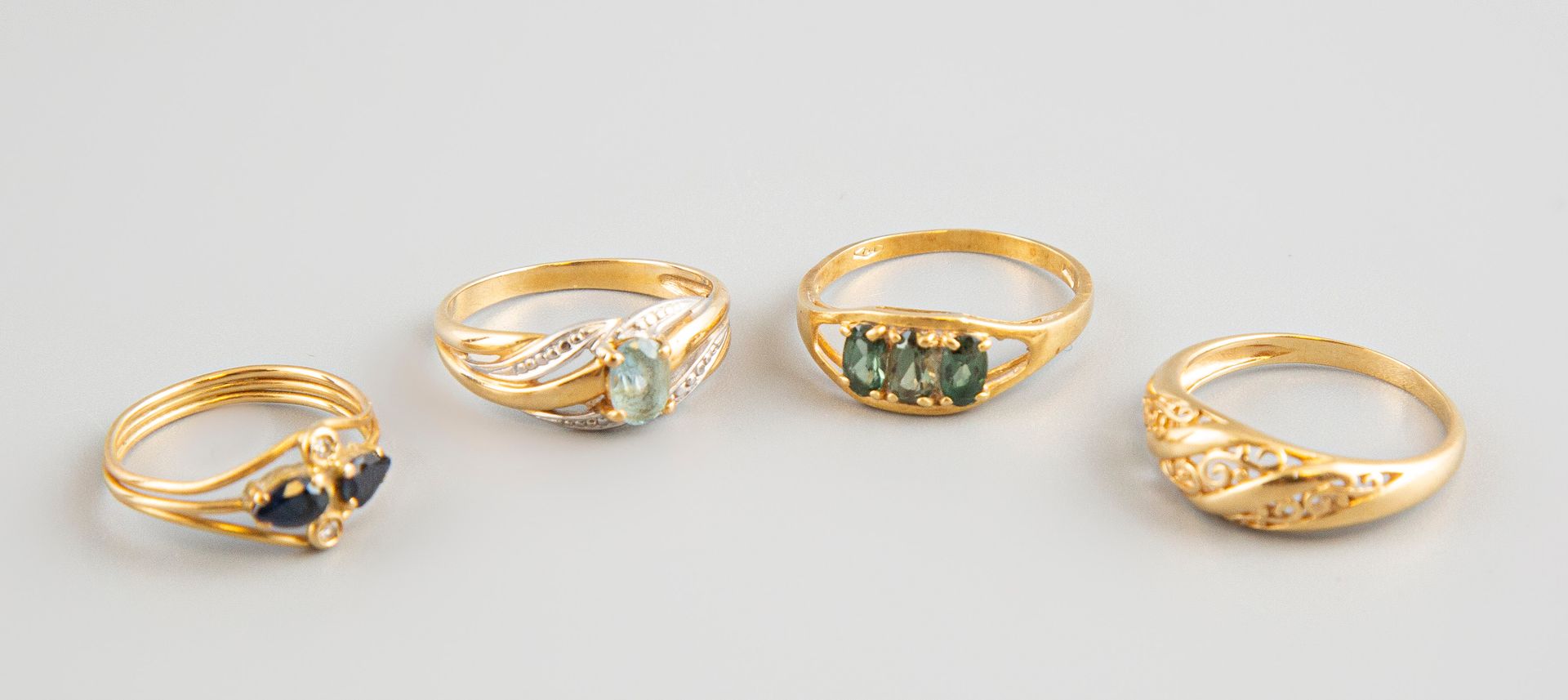 Null Lot of four 18K yellow gold rings with colored stones. Gross weight 8.3g.