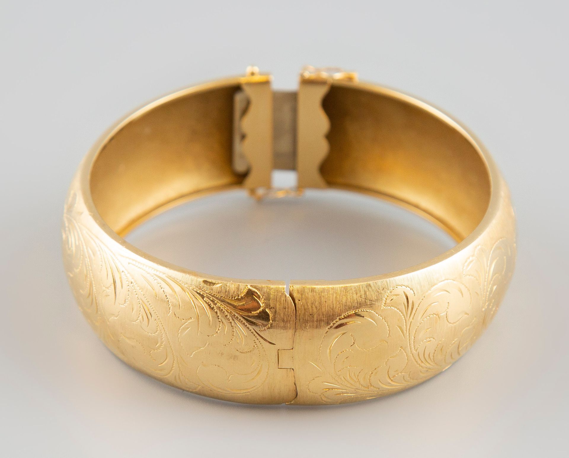 Null Bracelet jonc en or jaune 18K 750° gravé de motifs floraux. Poids 36,8g.