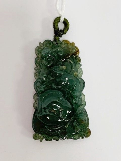 Null China. Colgante de jade celadón decorado con frutas y un conejo.