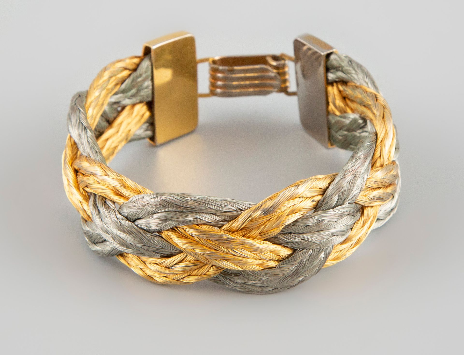 Null Large bracelet en métal doré et acier tressé.