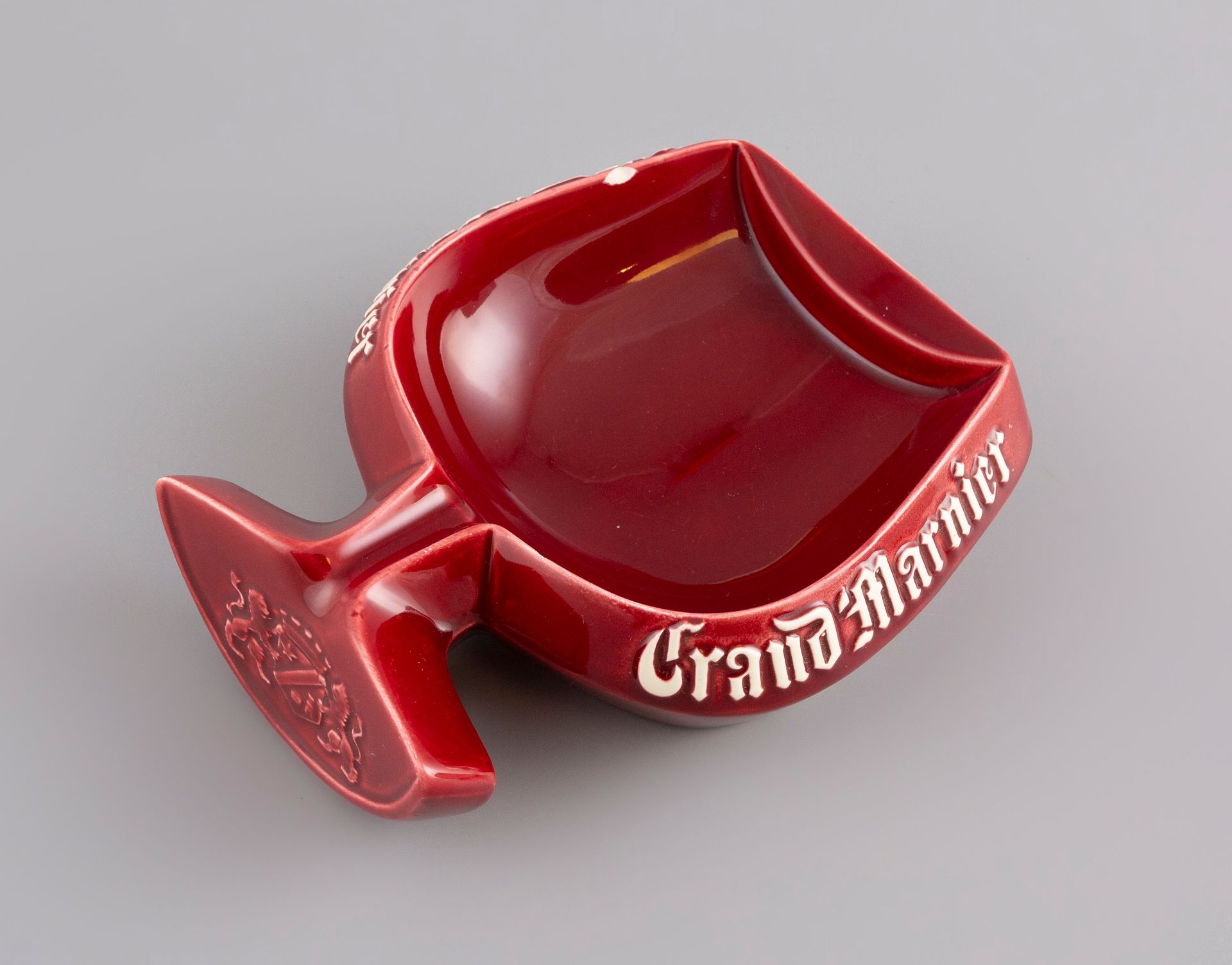 Null 酒红色背景的陶瓷烟灰缸GRAND MARNIER，19x16cm。(小碎片)。