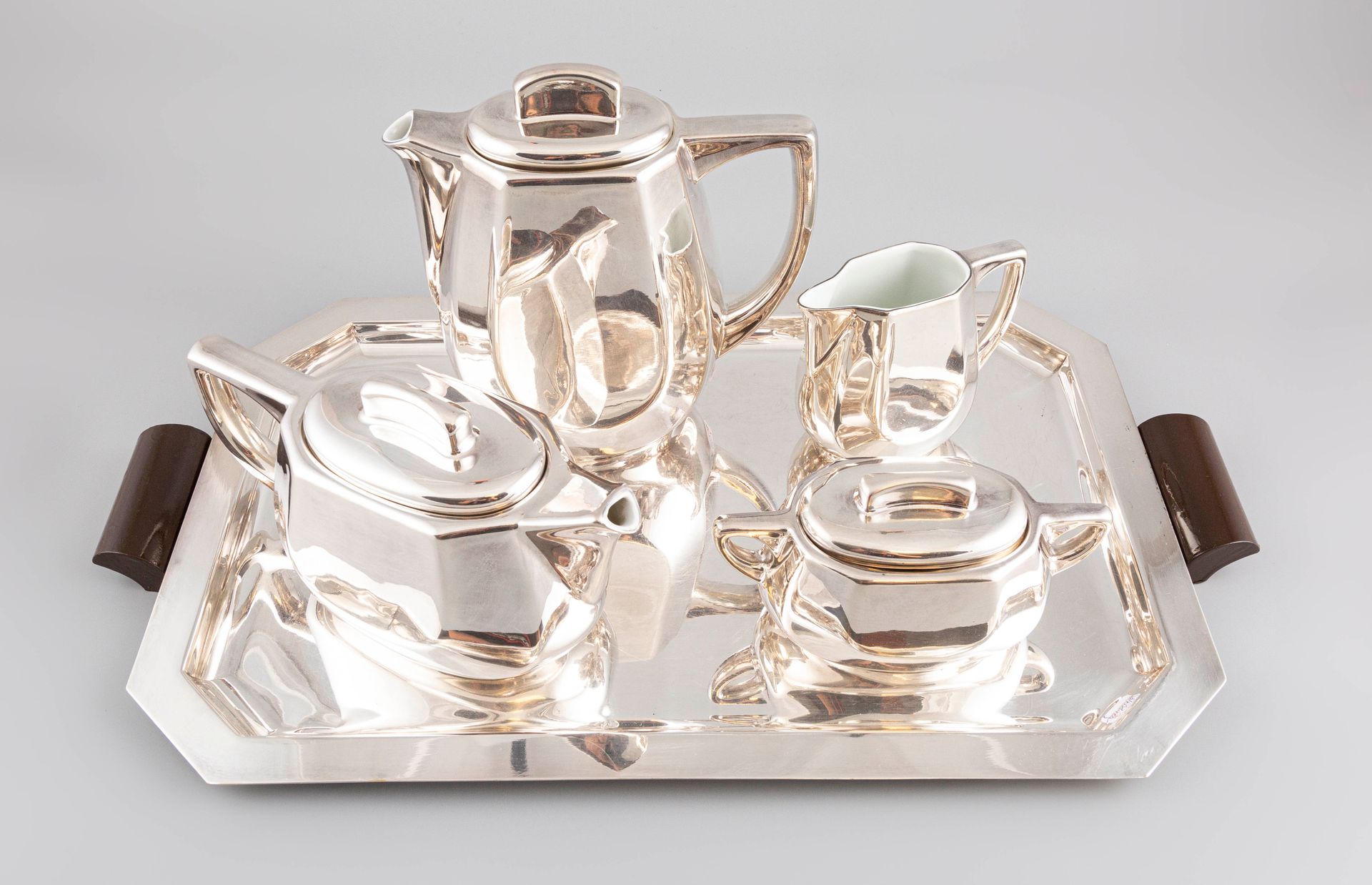Null 银色瓷器服务包括一个咖啡壶，一个茶壶，一个有盖的糖碗，一个牛奶壶和一个银色的金属托盘。(托盘已被划伤和损坏）。)