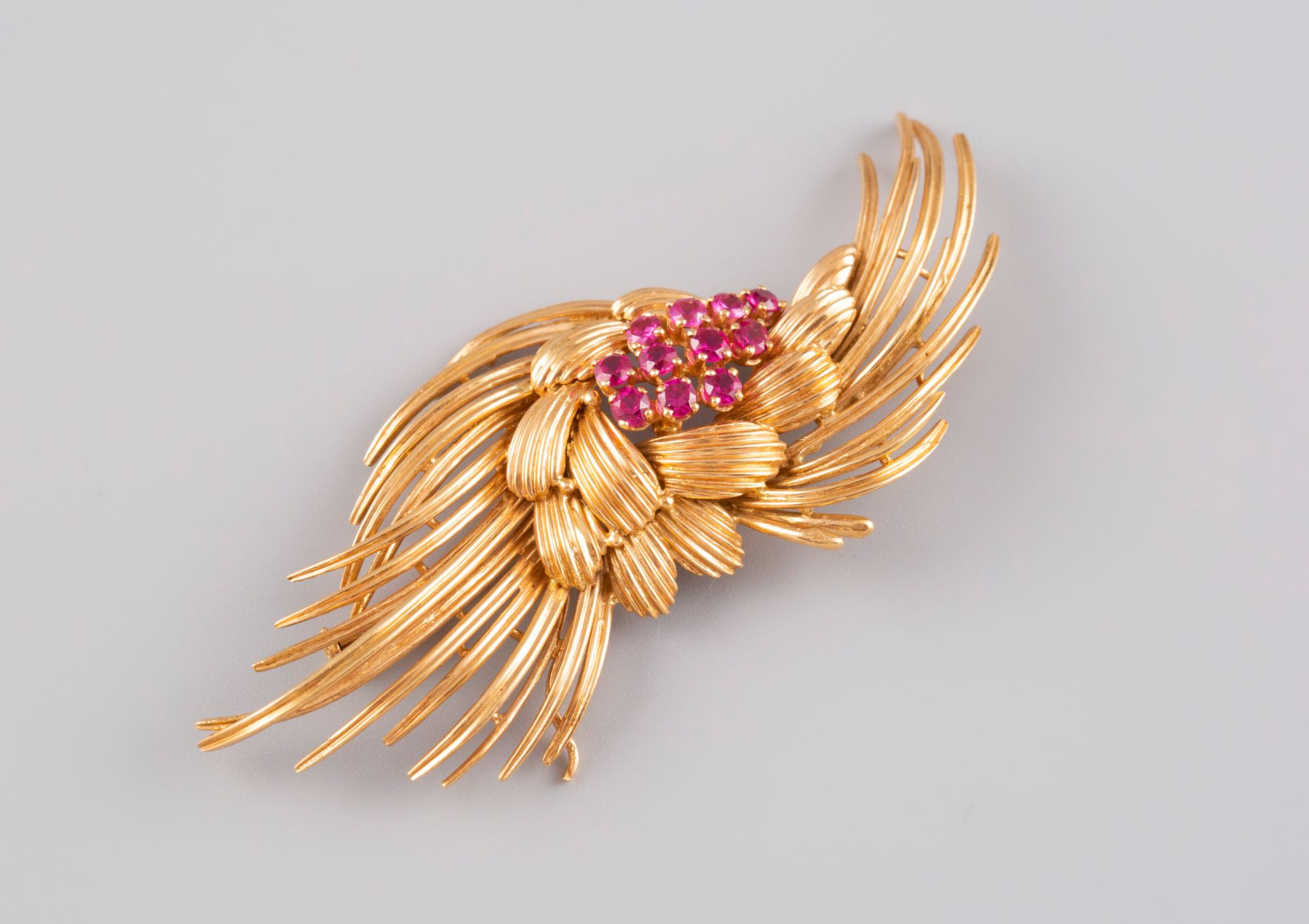 Null 
Stylized brooch in 18K yellow gold 750° set with eleven synthetic rubies. &hellip;