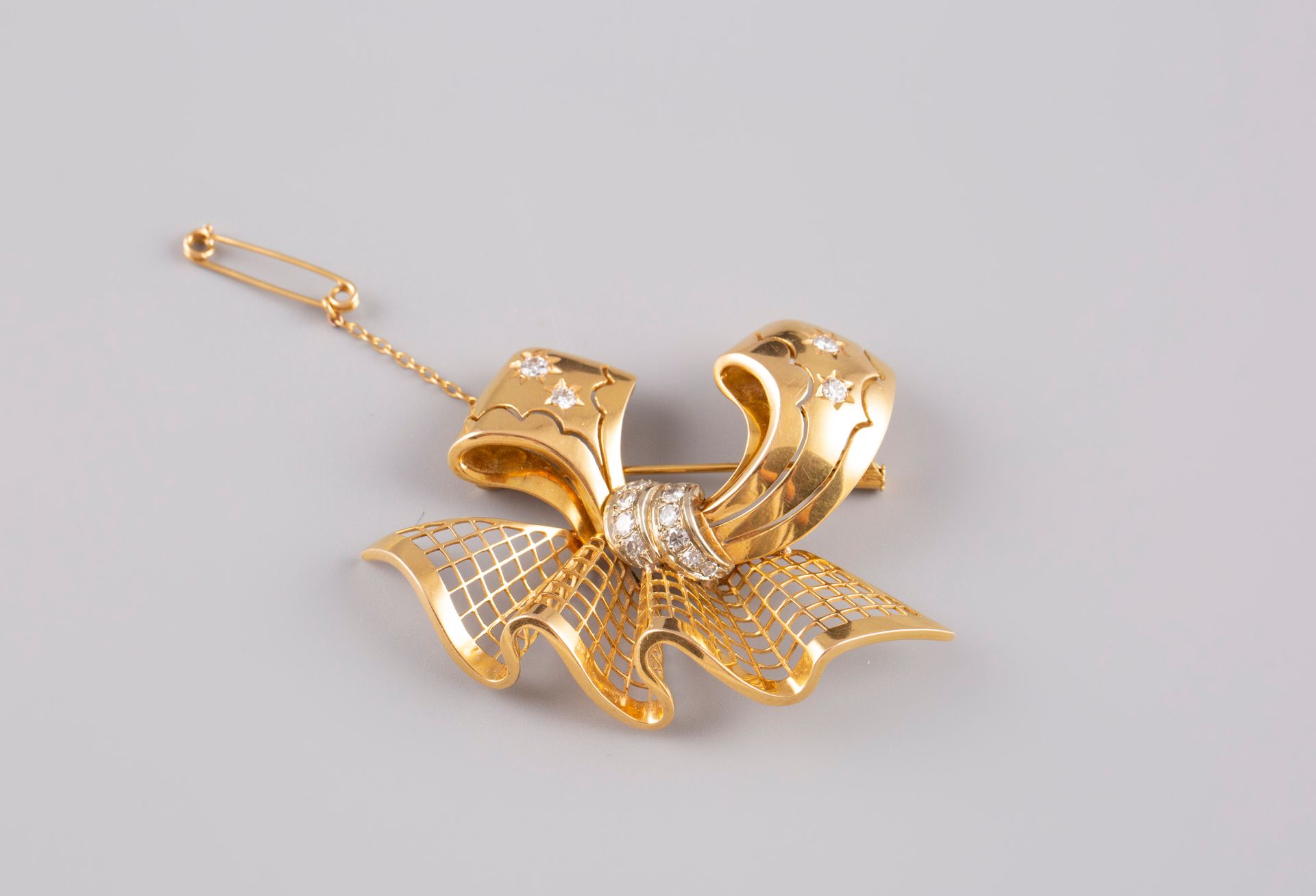 Null Broche noeud en or jaune 18K 750° sertie de petits brillants. PB:18,2g