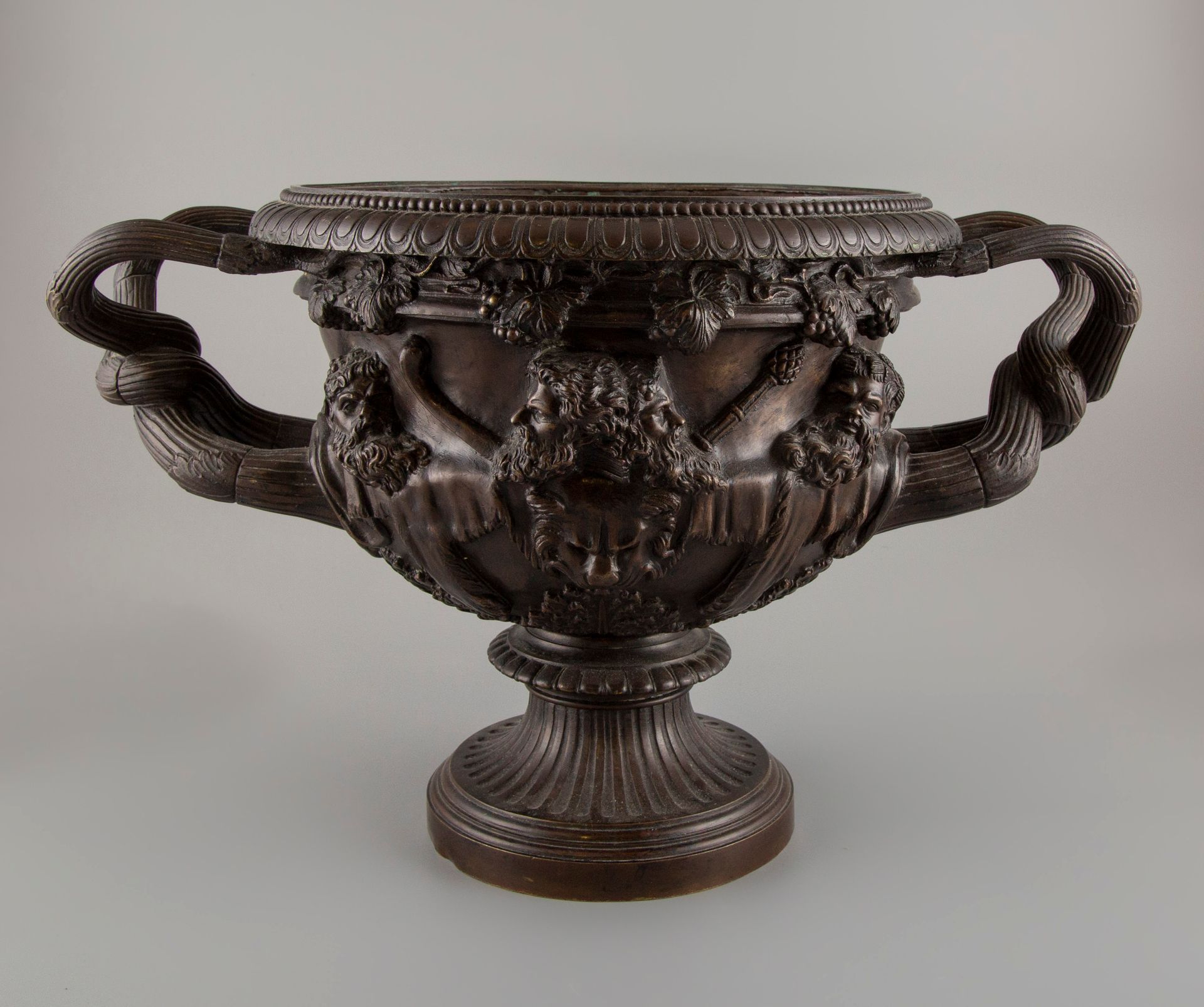 Null 一件棕色的带凹槽的青铜水壶，手柄扭曲，壶身有浮雕式的人物装饰。高：27厘米，深：28厘米