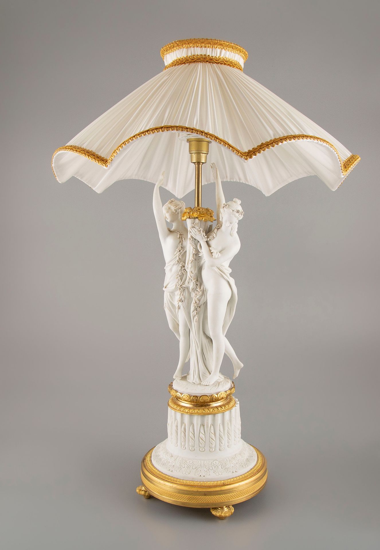 Null Bisque lamp base representing two Graces, the gilded bronze mount. H.:47cm