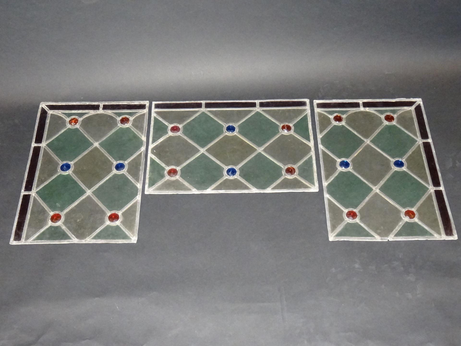 Null Suite de trois vitraux en verre coloré ornés de cabochons facettés. (Accide&hellip;