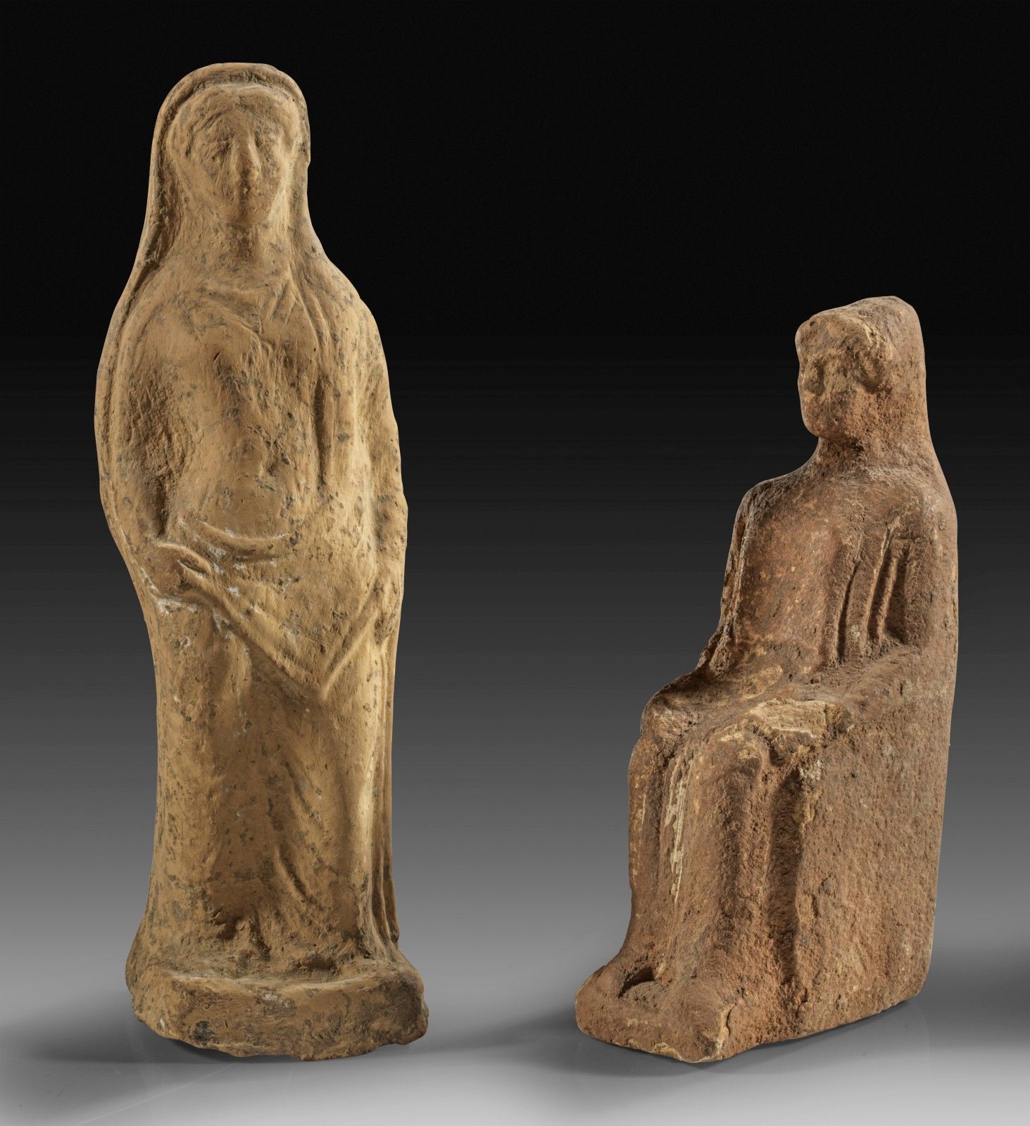 Null 两尊陶土制成的希腊雕像。坐着的女人。公元前5世纪。高11.8厘米。带着面纱的站立女孩掀开她的长袍。公元前4世纪，高16.1厘米。 2件!坐着的女孩表面&hellip;