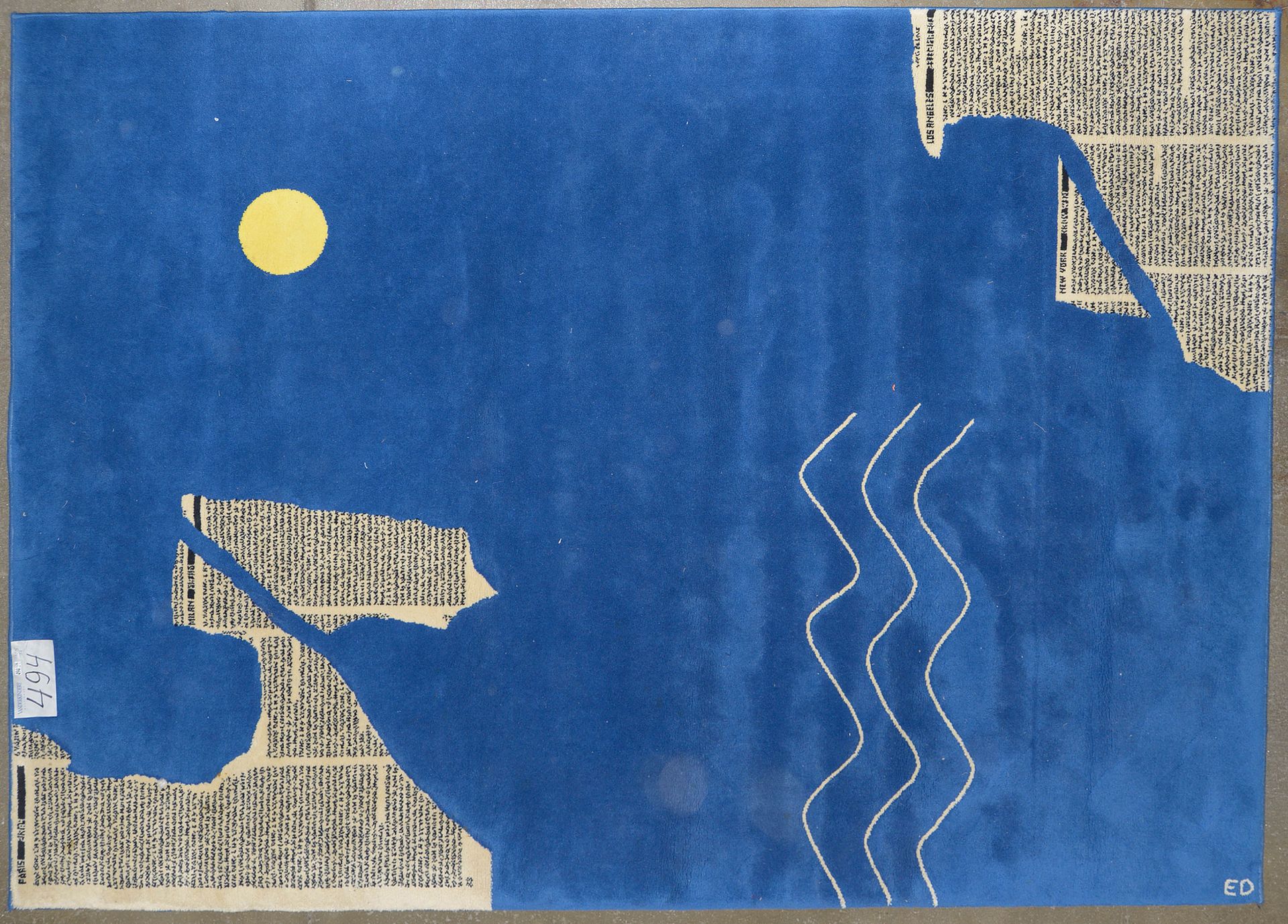 E. D. (XXème) 现代羊毛地毯上装饰着 "巴黎、纽约、洛杉矶等大城市的物品，以蓝色海洋为背景"。签名：E.D. 年代：20世纪下半叶。尺寸：+/-23&hellip;