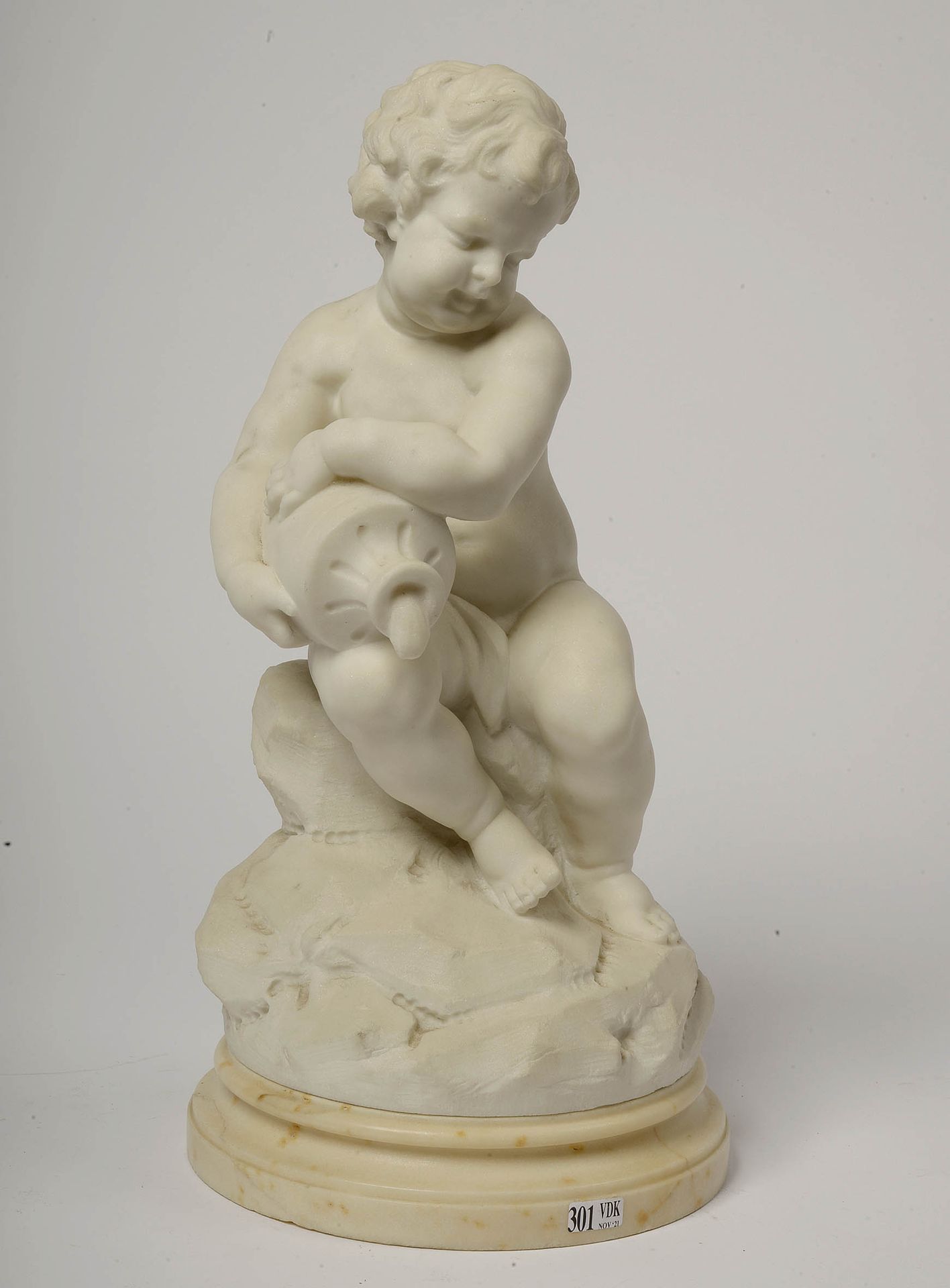 D'ASTE Joseph (1881 - 1945) 白色卡拉拉大理石的 "带水壶的小天使"，放置在一个白色大理石底座上。签名：D'Asté。意大利学校。高（&hellip;