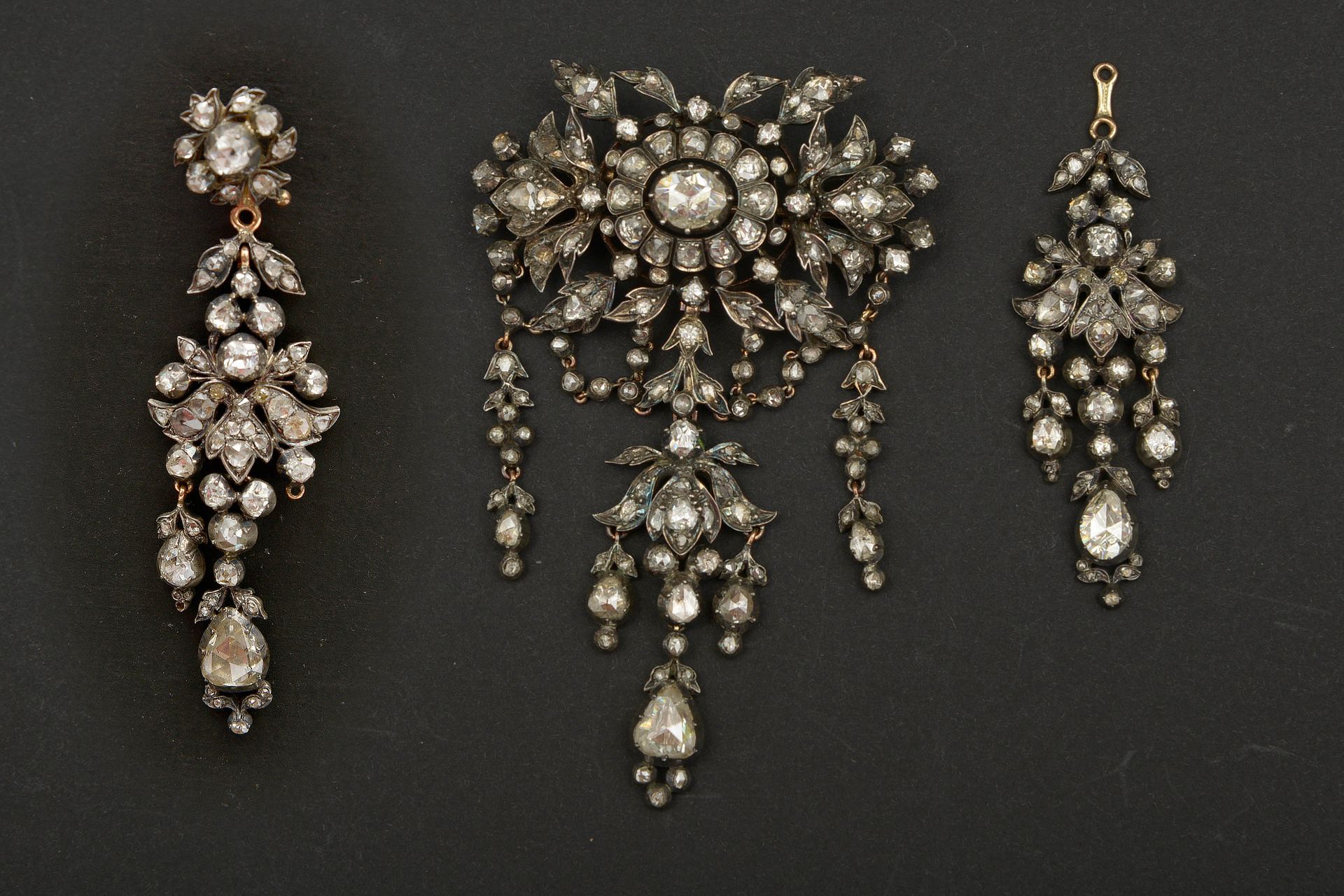 Null 罕见的套装包括一枚银质和18K黄金胸针和一对银质和18K黄金耳环，上面镶嵌着玫瑰切割钻石。年代：18世纪。(小姐)。装在原来的皮箱里。胸针尺寸：+/-&hellip;