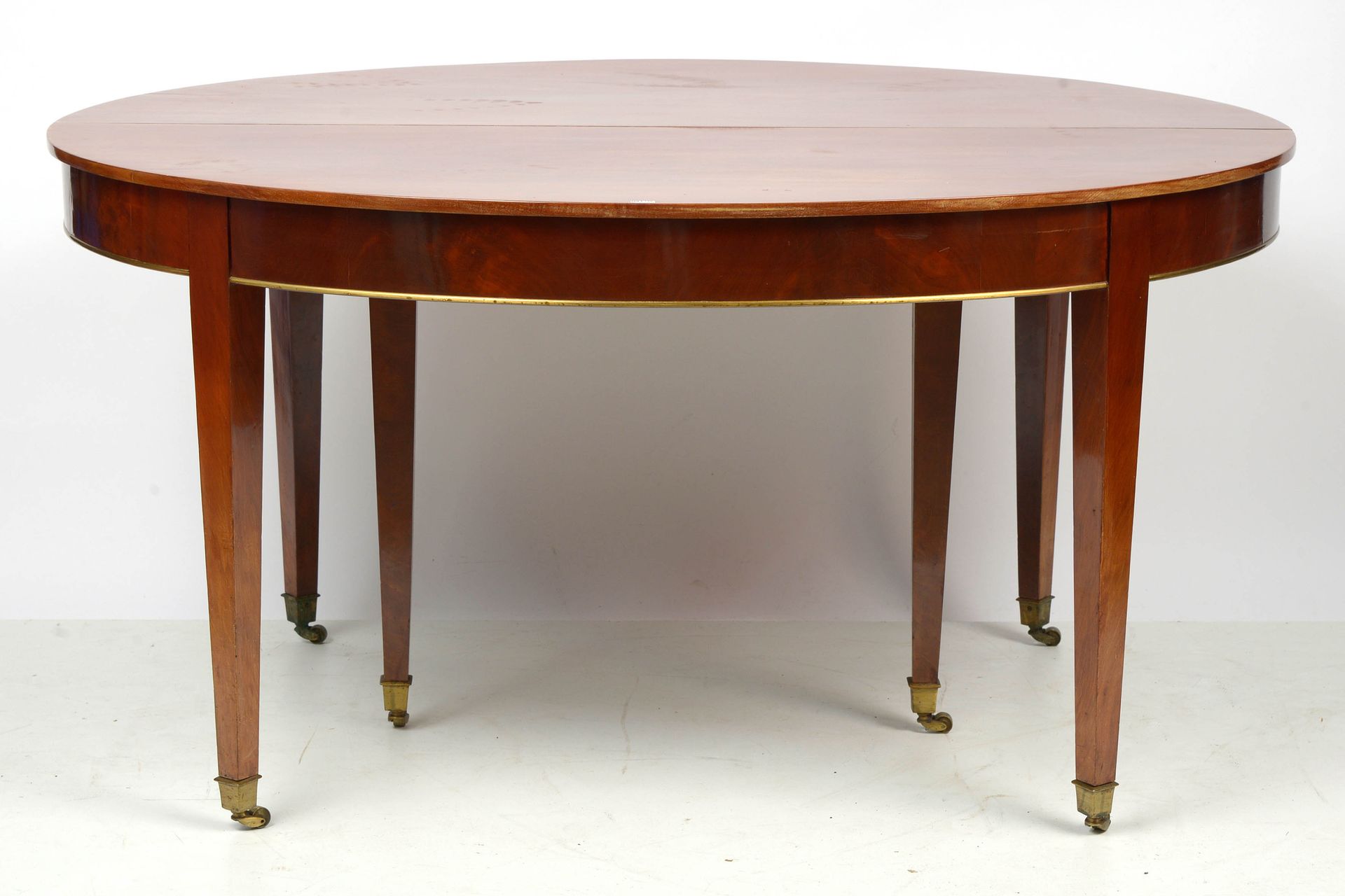 Null 桃花心木椭圆形扩展桌，六条腿，带脚轮和黄铜圆角。年代：18世纪末。Dim.(fermée):+/-147x75x116cm.