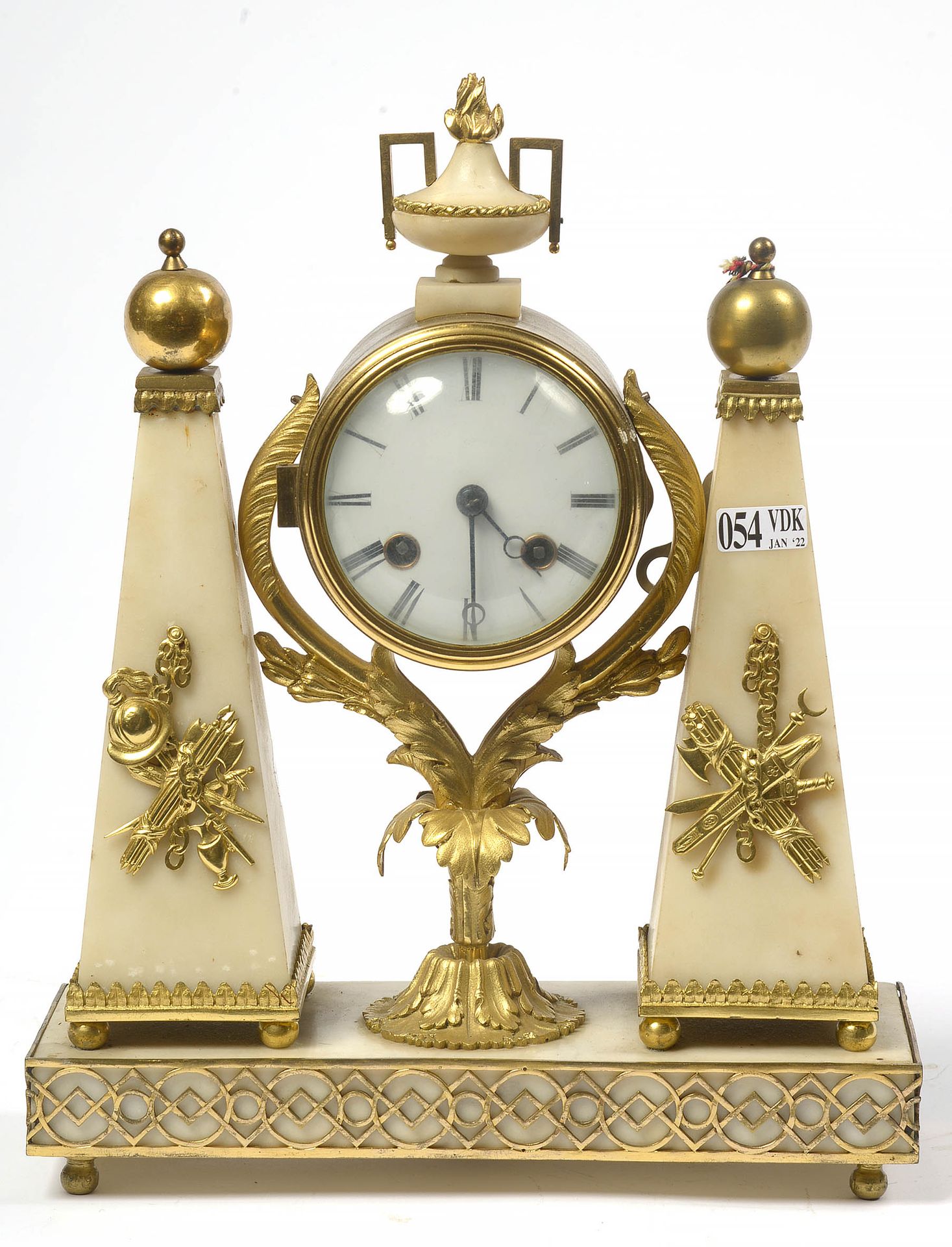 Null 白色大理石和鎏金青铜的小直隶门廊钟，有 "军事奖杯 "装饰。年代：18世纪末。18世纪的运动转化为刀刃。(表盘上有小的凹痕和轻微的*)。高：+/-31&hellip;
