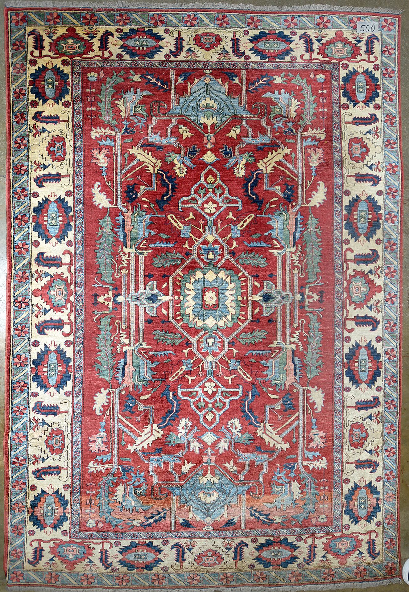 Null 手工制作的大型羊毛基尔曼地毯，在红色背景上装饰有中央几何形状的蓝色、红色、绿色和米色的花纹图案。波斯人的工作。尺寸：+/-391x264厘米。