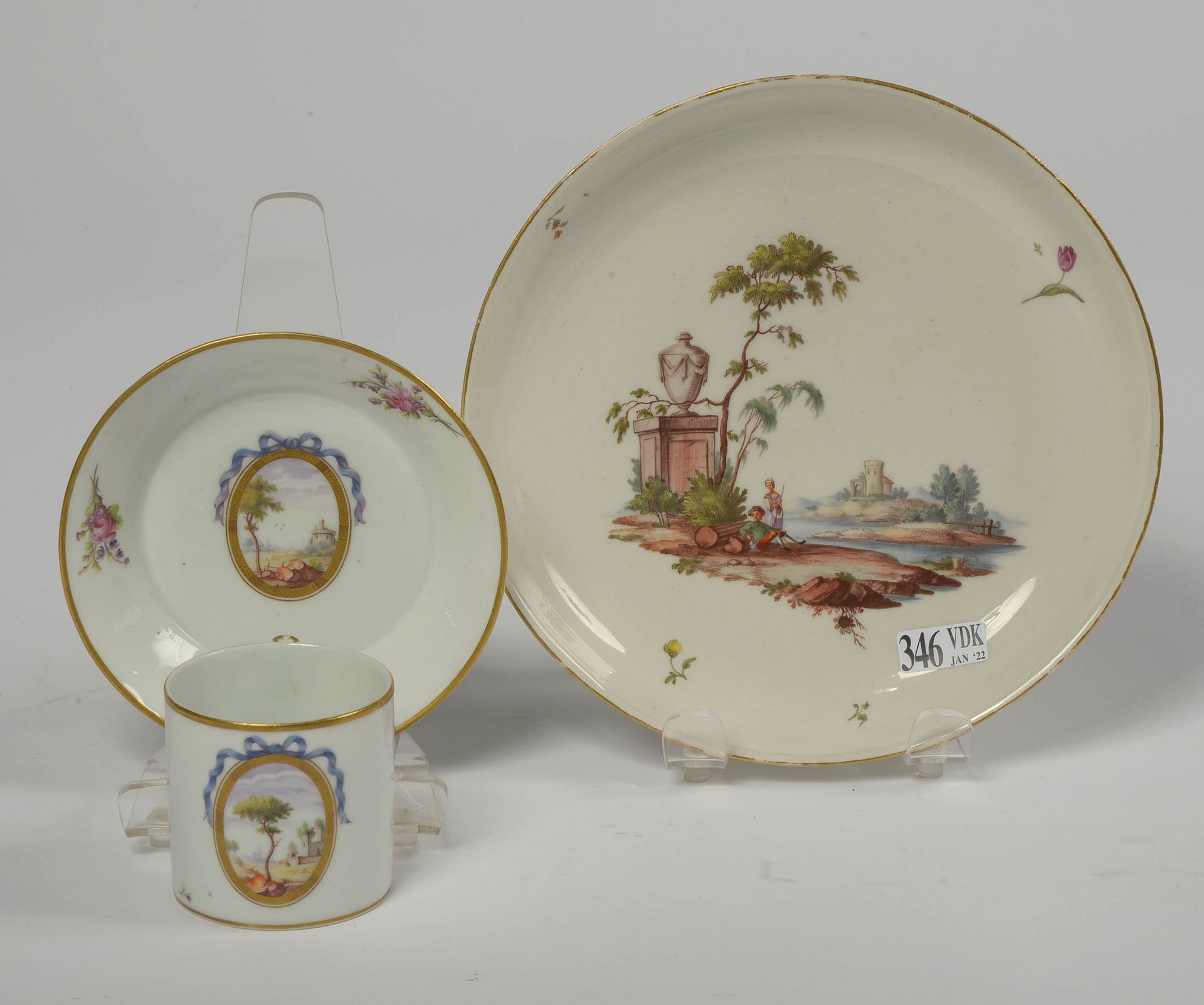 Null 一套两件，包括：路德维希堡的多色瓷器，装饰有 "湖面上的农民夫妇"。一个Niderviller多色瓷杯和碟子，上面装饰着一个带有丝带的奖章的 "风景"&hellip;