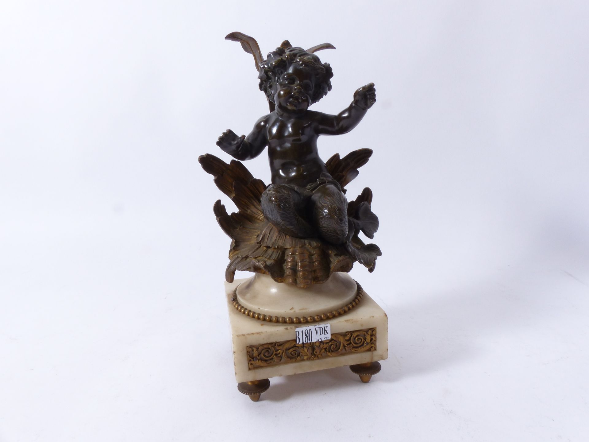 Null Angelot in bronze with brown patina on marble base. H: 27 cm.