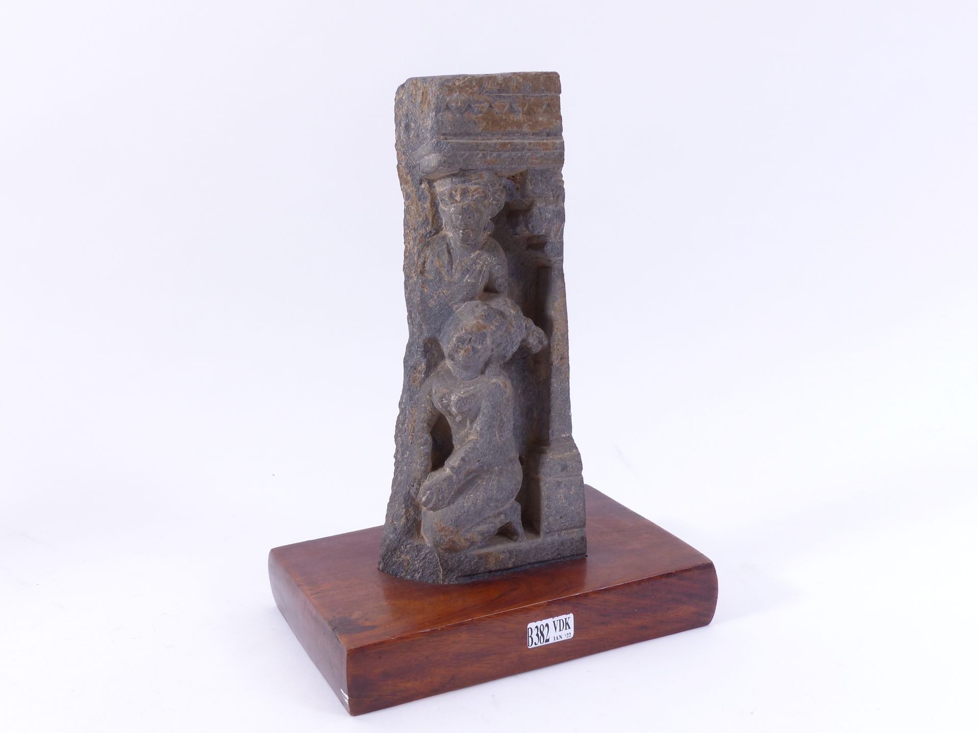 Null 黑片岩高浮雕的一部分，刻有两个 "字符"。犍陀罗的工作。时期：公元2至3世纪。安放在一个木质底座中。(1980年以前收集的)。高（不含底座）：+/-2&hellip;