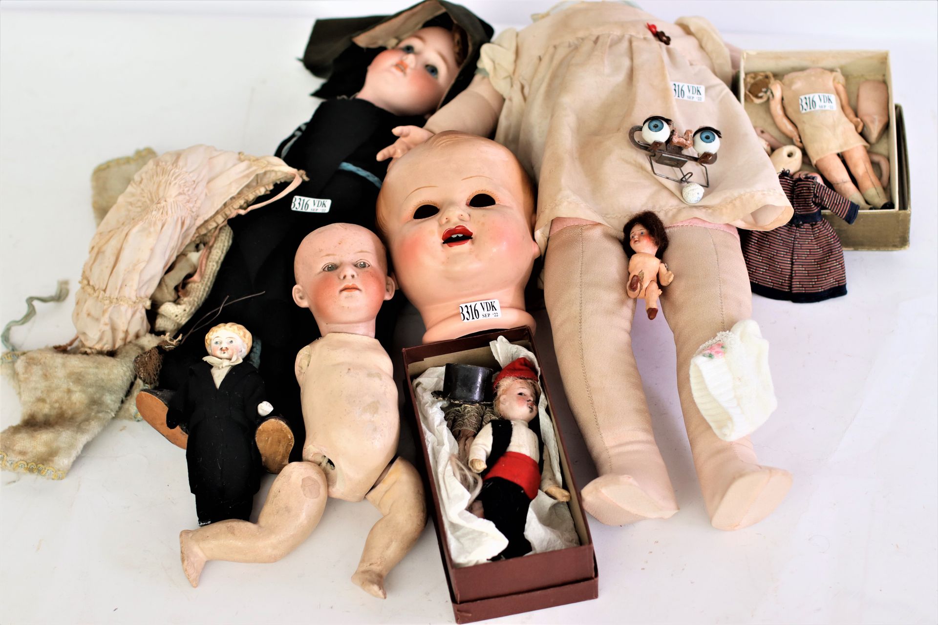 Null A bathing doll and a series of dolls with porcelain heads, doll clothes, ..&hellip;
