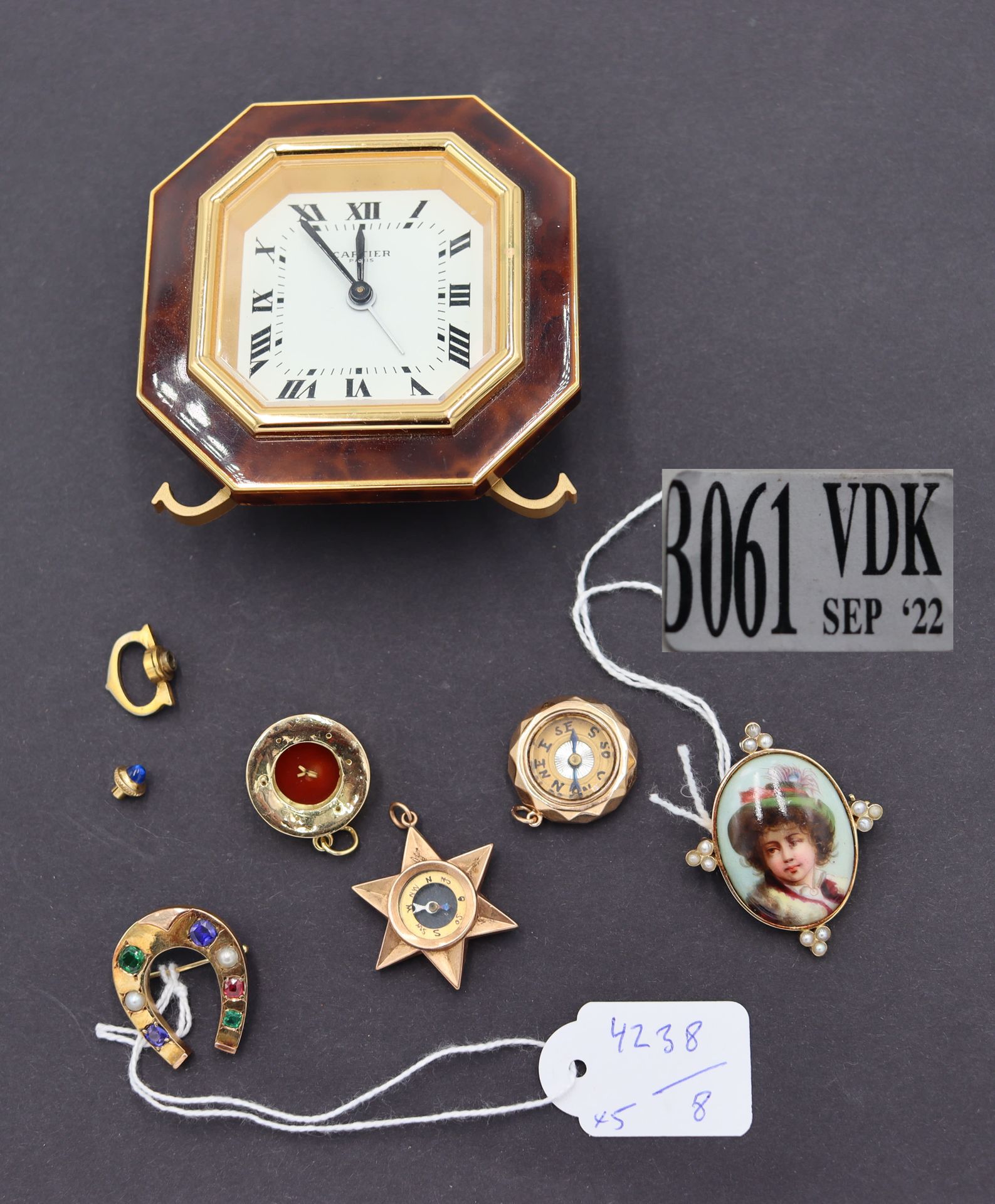Null 4件18K金吊坠和胸针（重量：30g）。包括一个鎏金金属罗盘吊坠和一个卡地亚闹钟（原盒）。出处：前Springuel收藏，Huy的Château de&hellip;