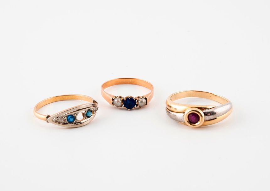 Null Three gold rings (750) of several shades decorated with coloured stones:

-&hellip;
