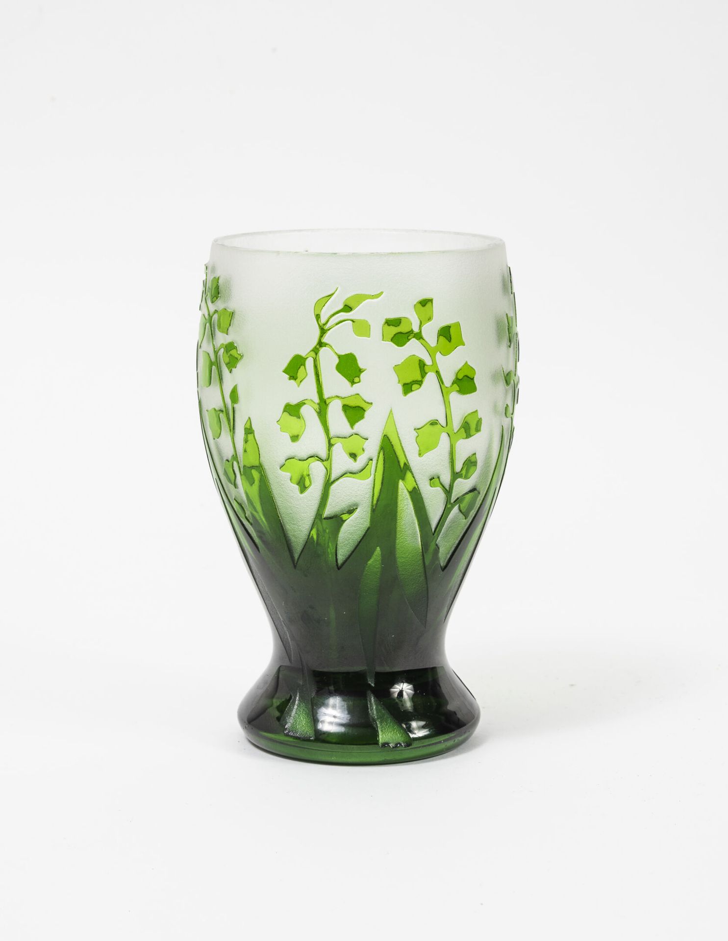 CHRISTIAN DIOR 小花瓶，小跟头，绿色内衬玻璃，半透明的磨砂底。

铃兰花枝的旋转装饰。

底座下有签名C D。

H.13.5厘米。