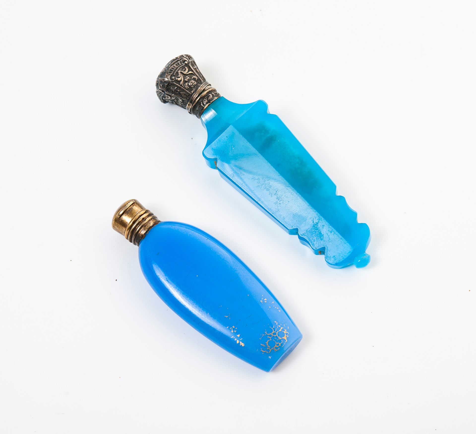 FRANCE, XIXEME SIECLE 两个盐瓶，扁平的蓝色乳白玻璃或切割的蓝色有色玻璃瓶身，带有卵石或镀金丝的遗迹。

镶座和铰链盖为纯银或白色鎏金银（8&hellip;
