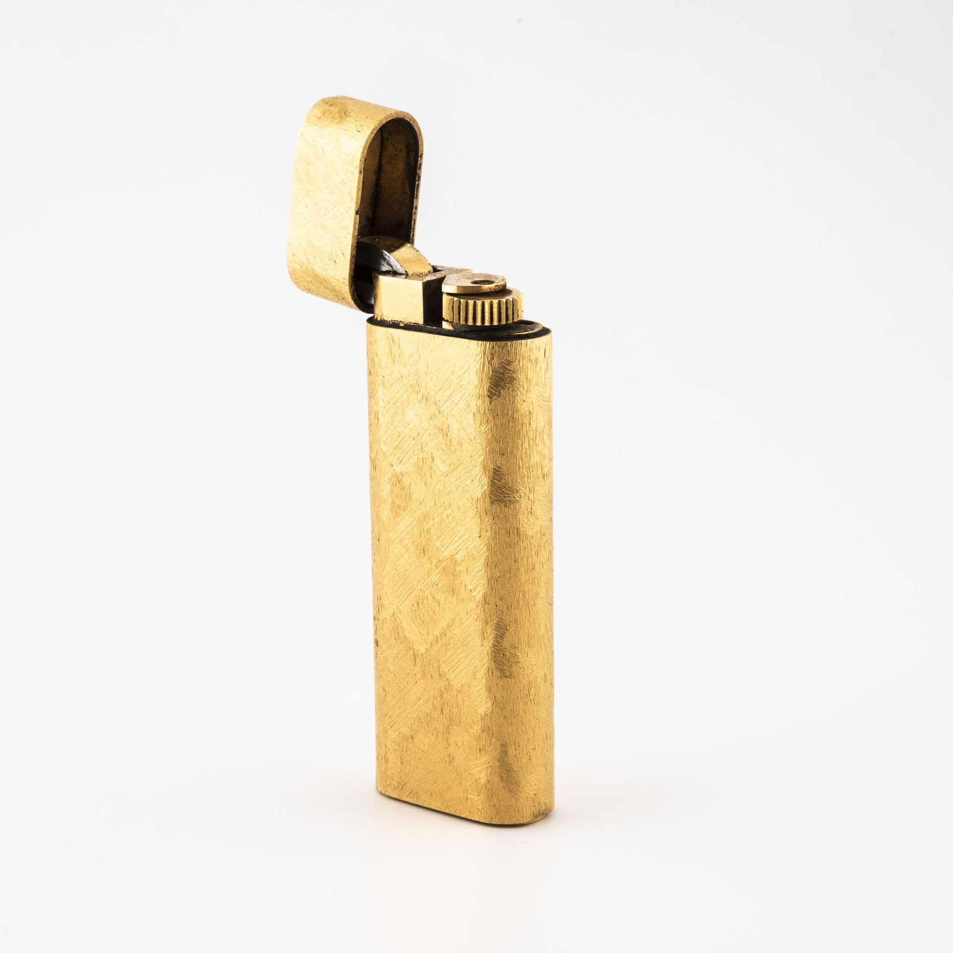 CARTIER, Paris Briquet de poche en métal doré amati. 

Signé. 

Numéroté 384370.&hellip;
