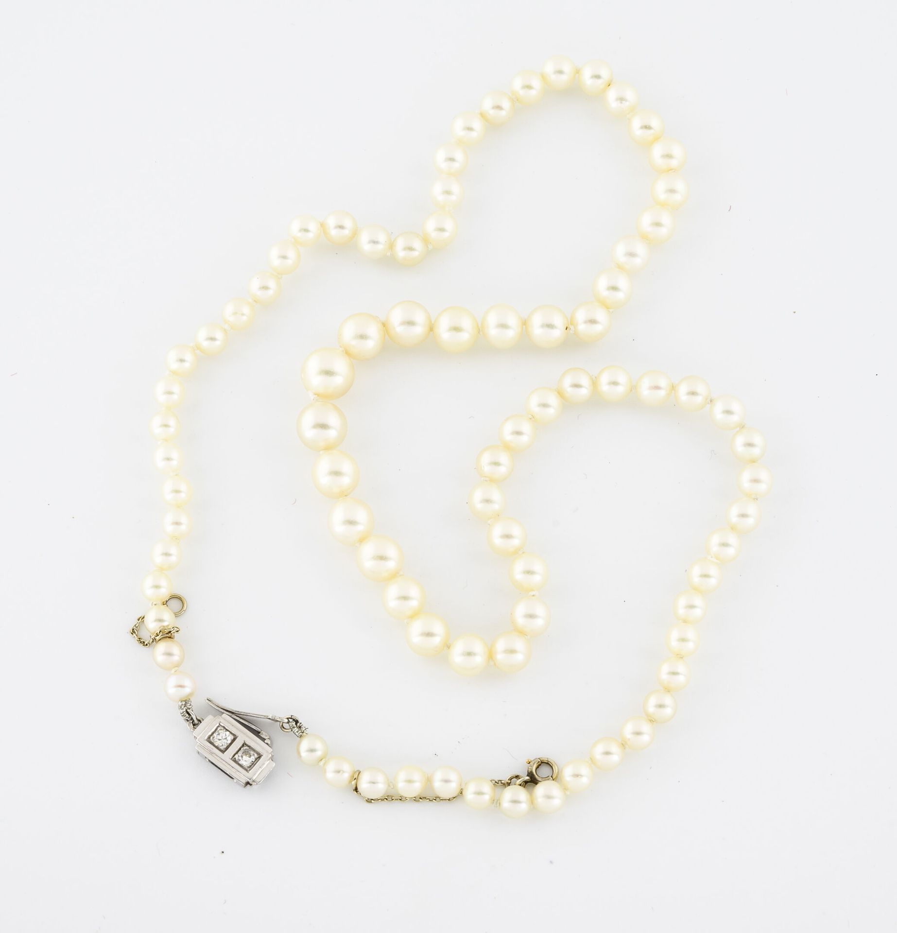Null 带白色养殖珍珠的项链。

白金(750)表扣，镶嵌两颗明亮式切割钻石，采用种子镶嵌法，有八个安全别针。

毛重：16.5克。- 长度：46厘米。
