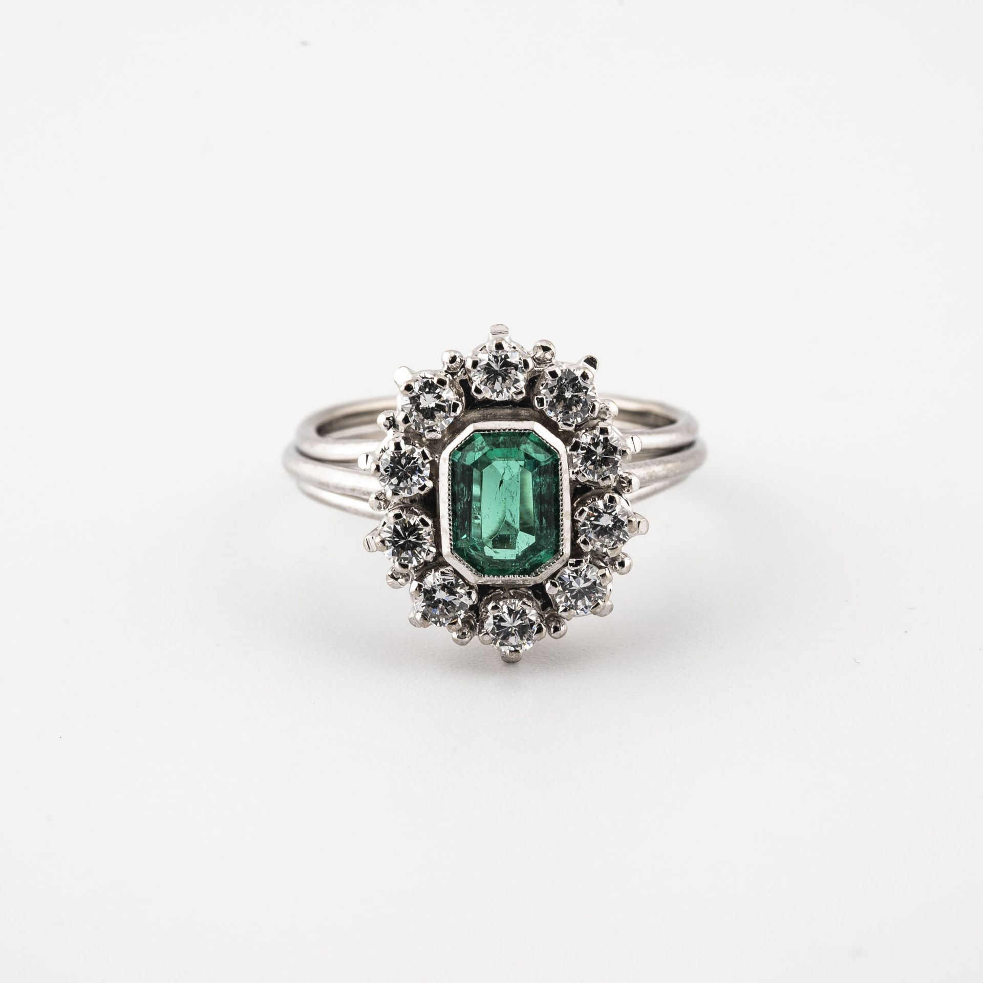 Null A white gold (750) filigree ring centered on a rectangular cut emerald in a&hellip;