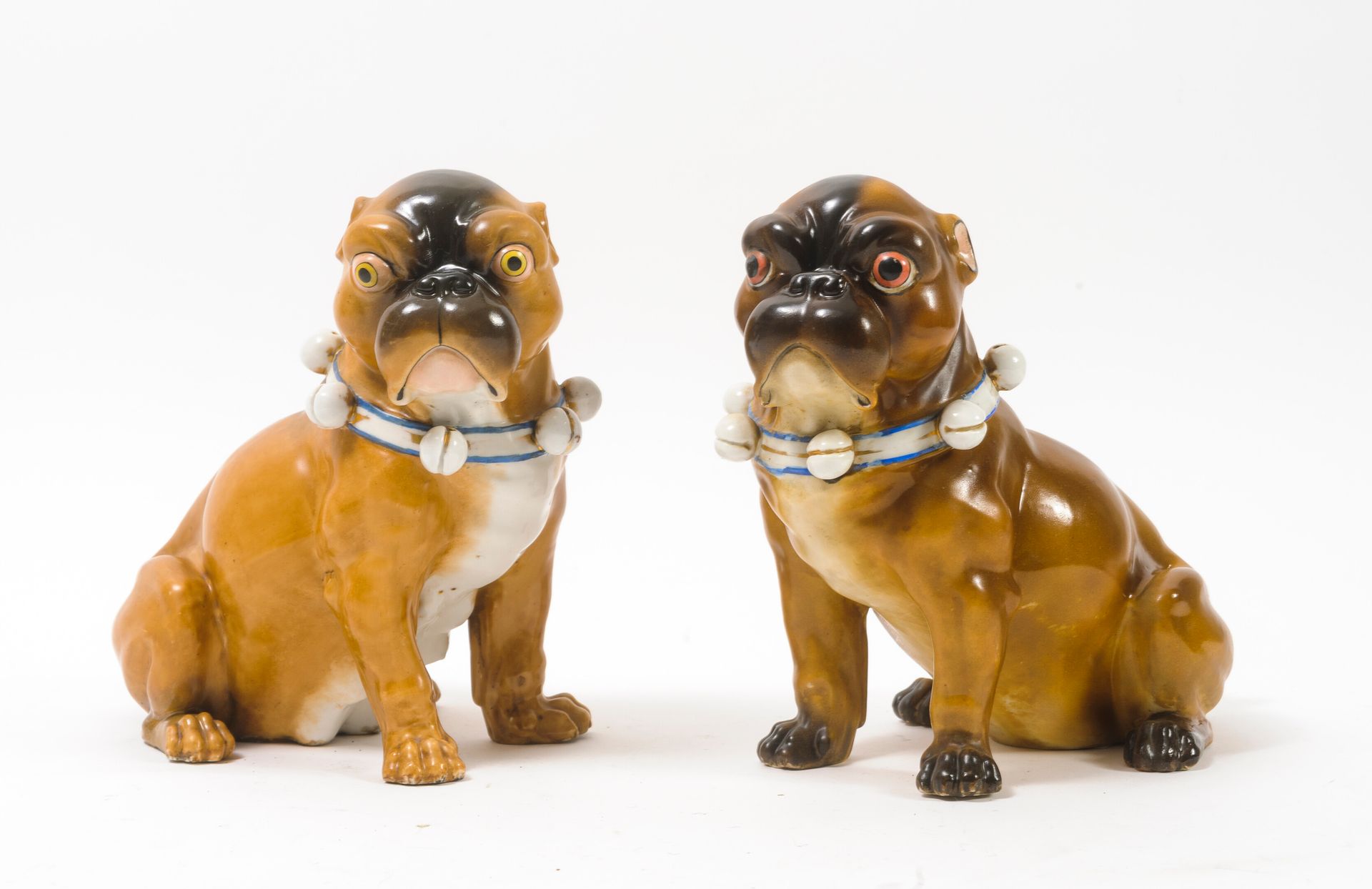 Null A pair of sitting fawn and brown pugs in polychrome porcelain with gold emb&hellip;