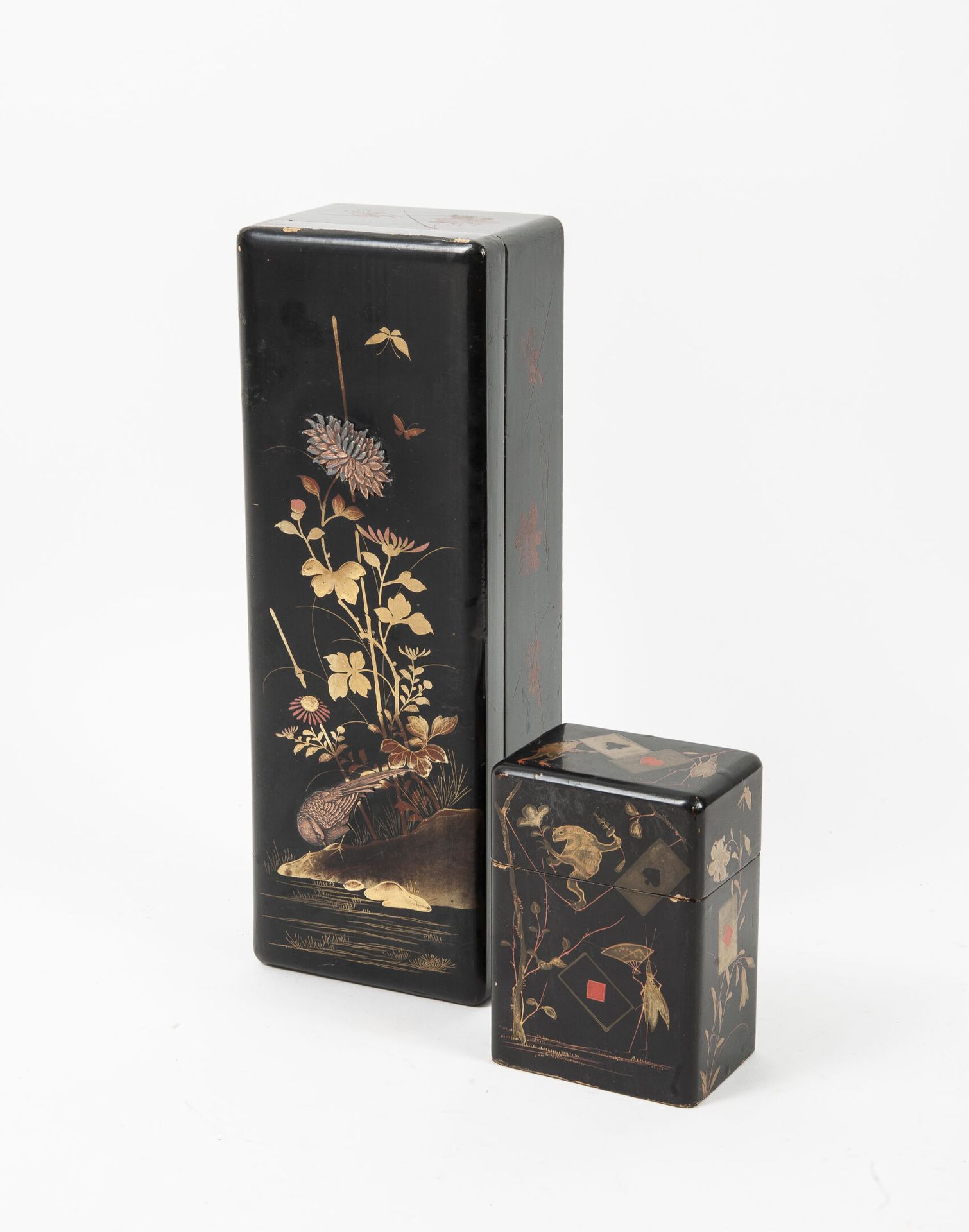 JAPON, début du XXème siècle 两个多色和镀金的黑底漆木箱。

- 一个手套箱，装饰着一只由花和叶组成的鸟，有镀铜的金属镶嵌。

黑色&hellip;
