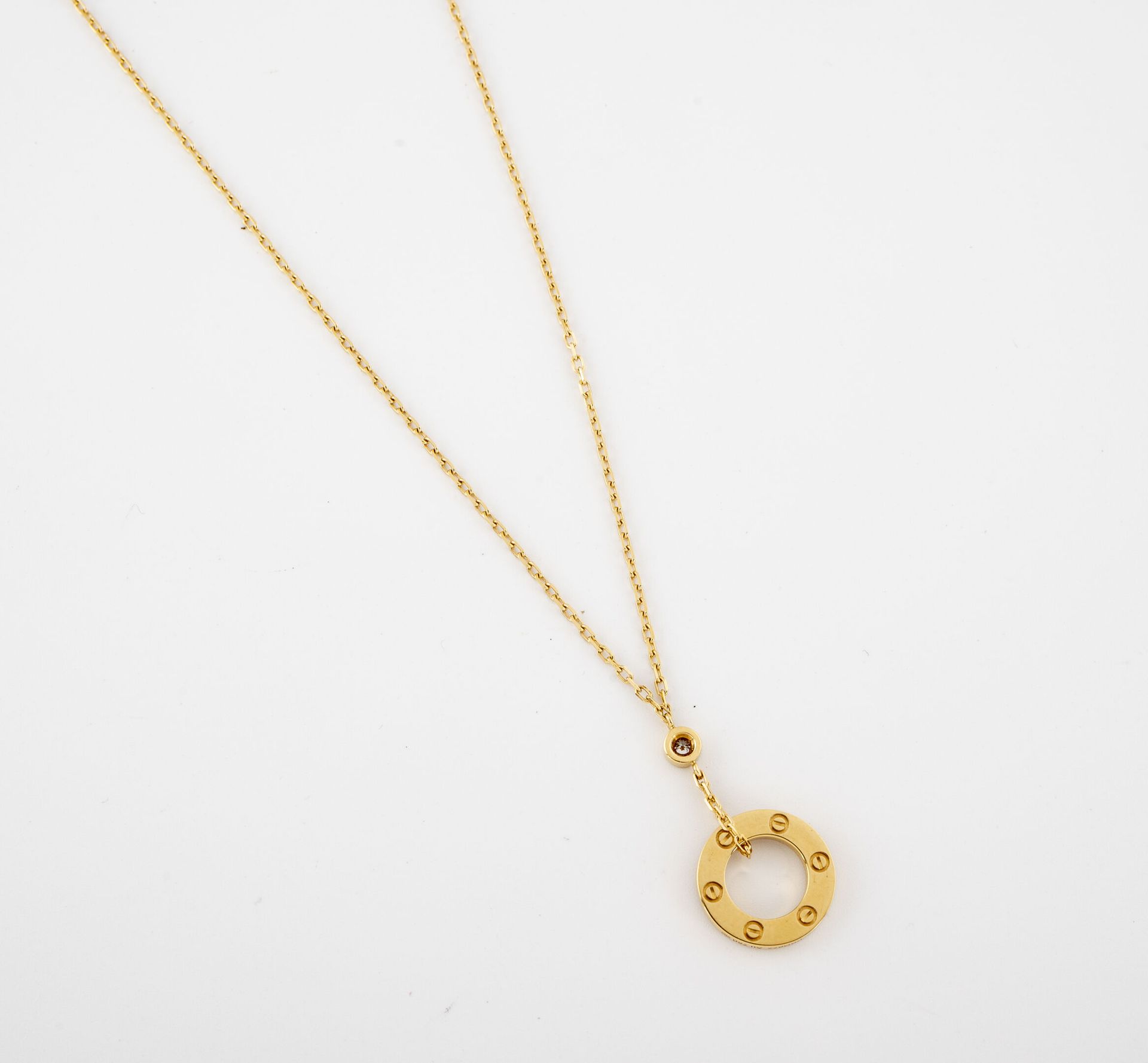 CARTIER, Love 黄K金（750）项链，托着一个镶有小型明亮式切割钻石的戒指吊坠。

龙虾扣。

有签名和编号的BBG977。

毛重：6.3克。- &hellip;