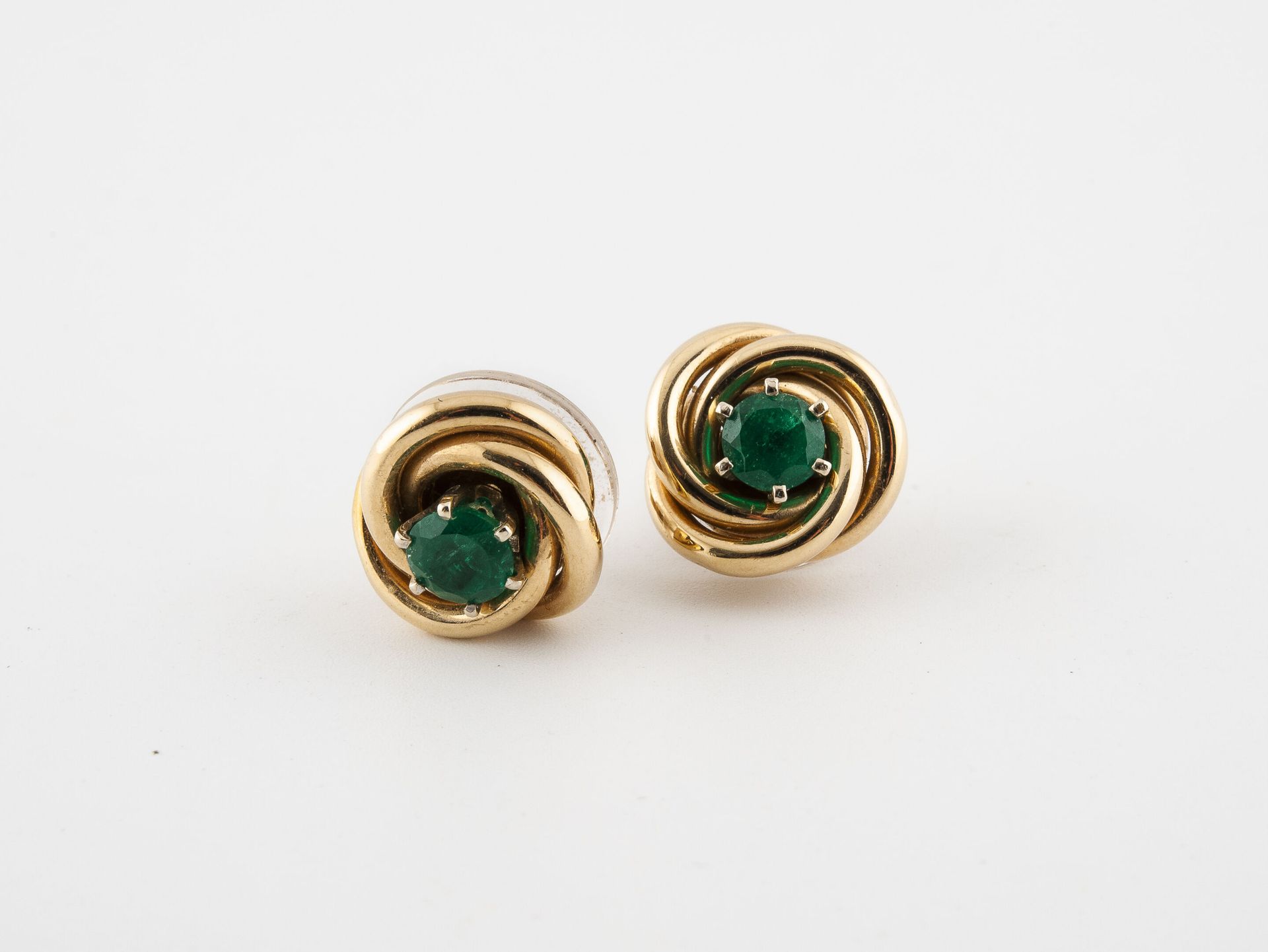 Null 一对黄金（585）耳环，以爪式镶嵌的圆形刻面祖母绿为中心，有一个可移动的扭曲黄金（585）元素。

总毛重：4.9克。- 直径：1.3厘米。

因使用&hellip;