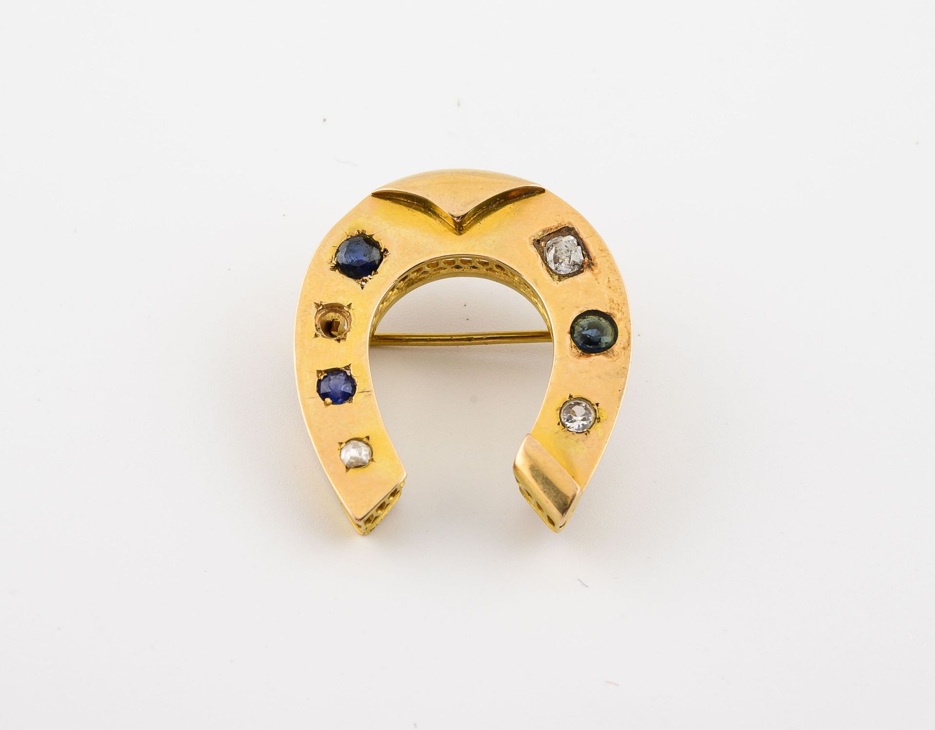 Null Yellow gold (750) horseshoe brooch set with faceted colored stones. 

Pin i&hellip;